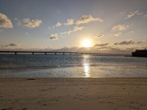 伊良部大橋の向こうに沈む夕日と、浜に映る光