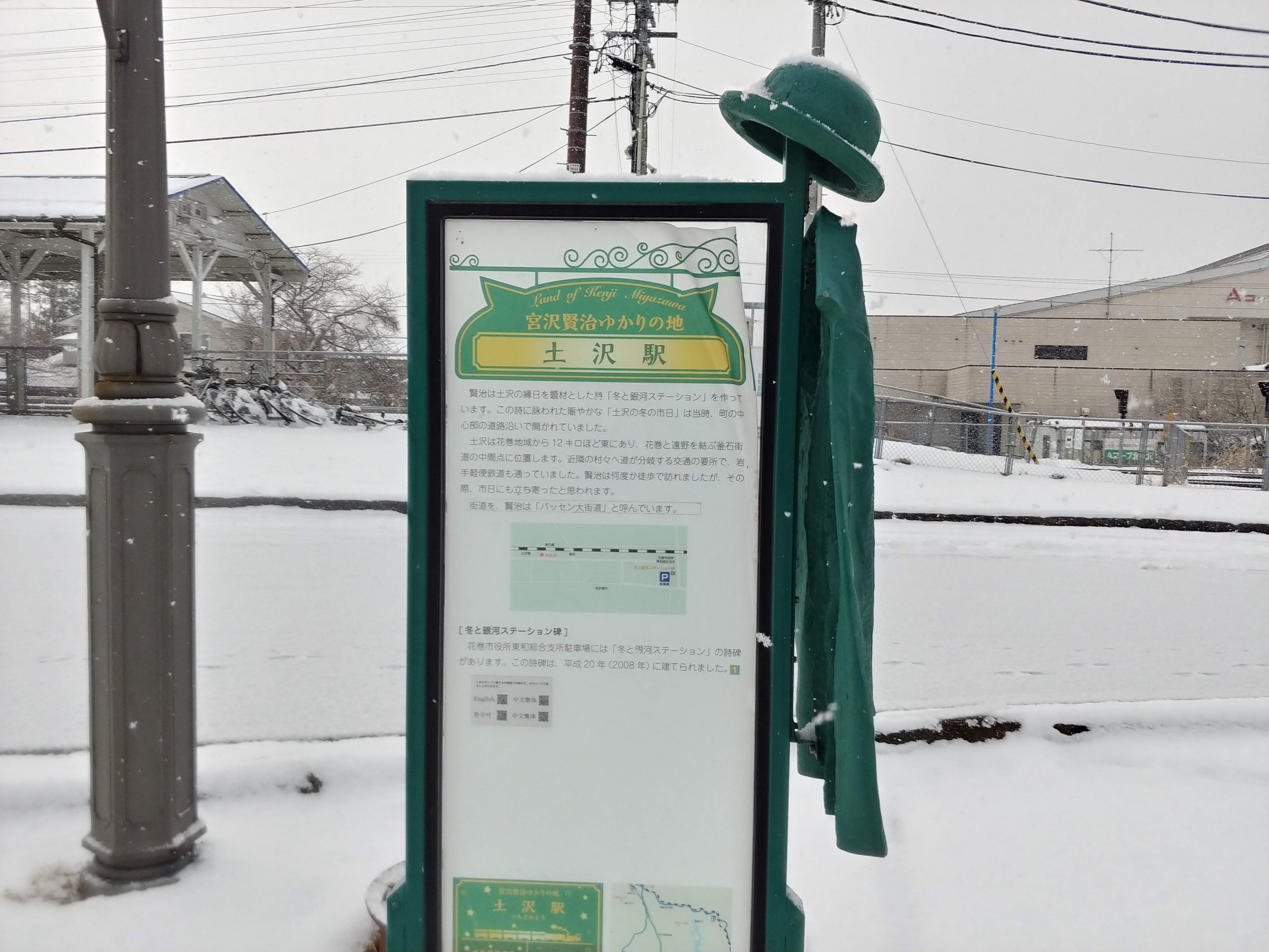 土沢駅の案内板と帽子とコート