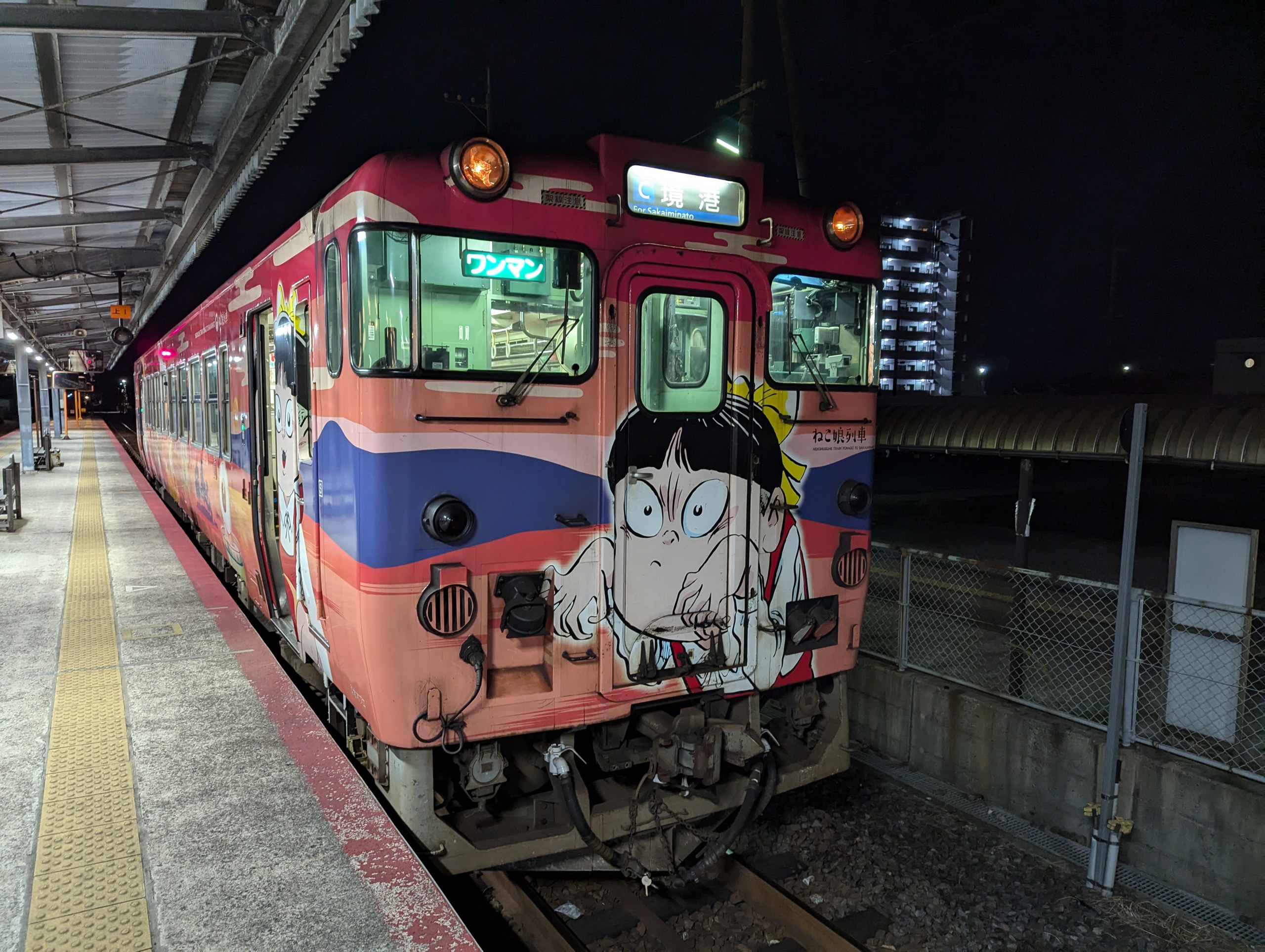 夜の境港駅のホームに停まる、ねこ娘が大きく描かれた鬼太郎列車