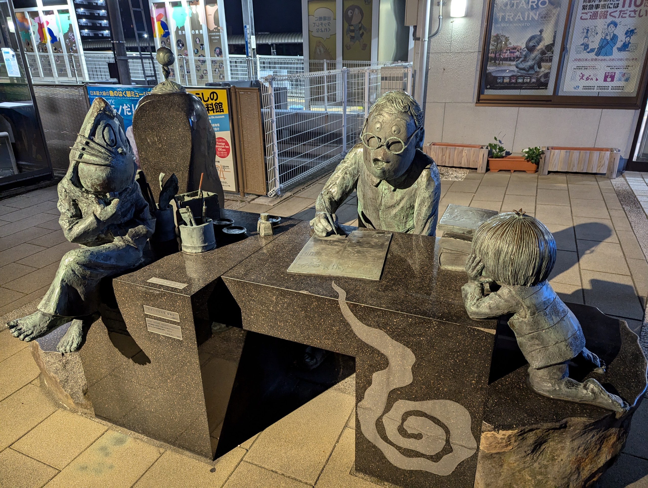 境港駅前にある、机で漫画を描く水木しげるさんと、のぞき込む鬼太郎たちのブロンズ像