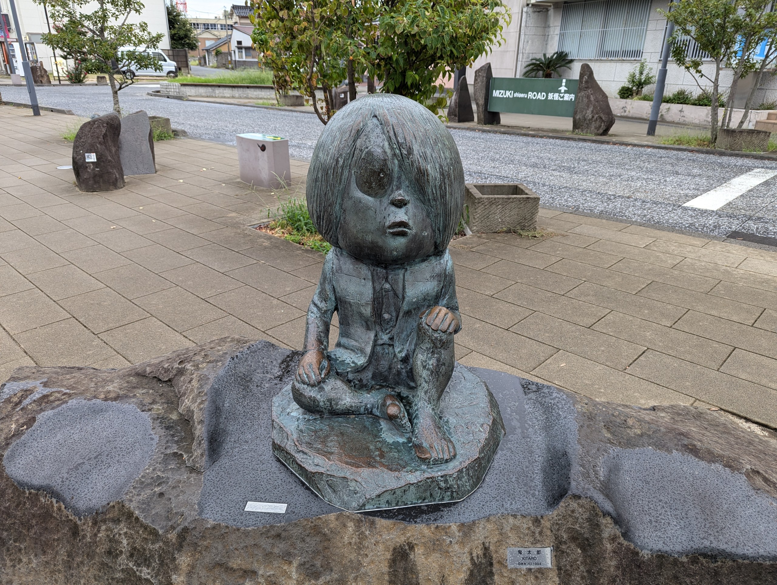 岩の台座の上に立つ鬼太郎のブロンズ像