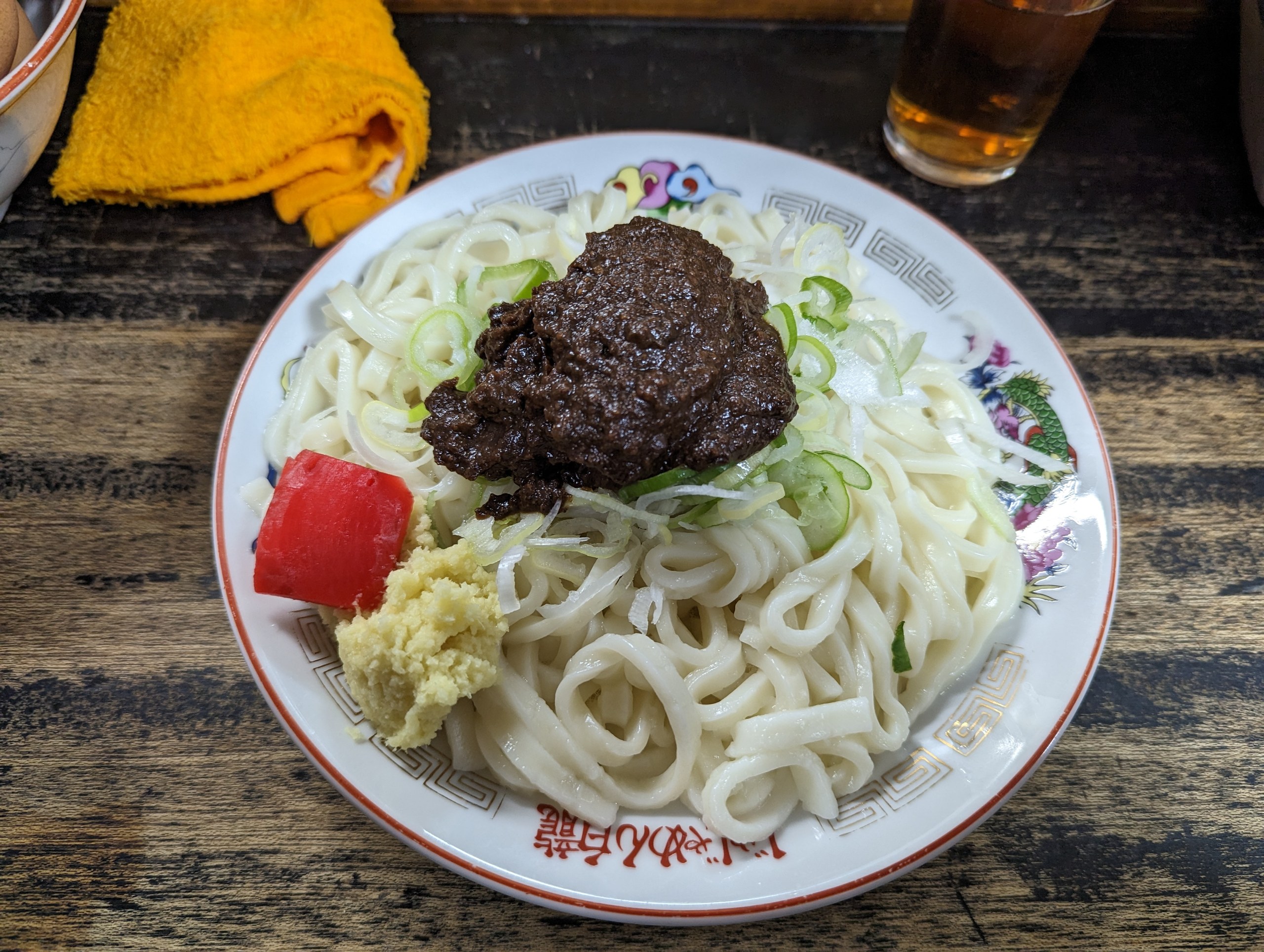 平たい麺に肉味噌ときゅうり、紅しょうがをのせたじゃじゃ麺
