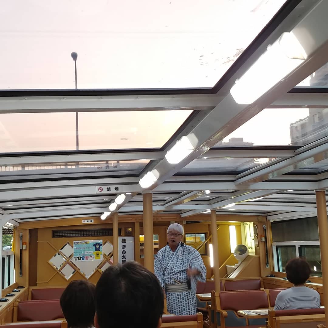 遊覧船の中で話す、ゆかた姿の落語家さん