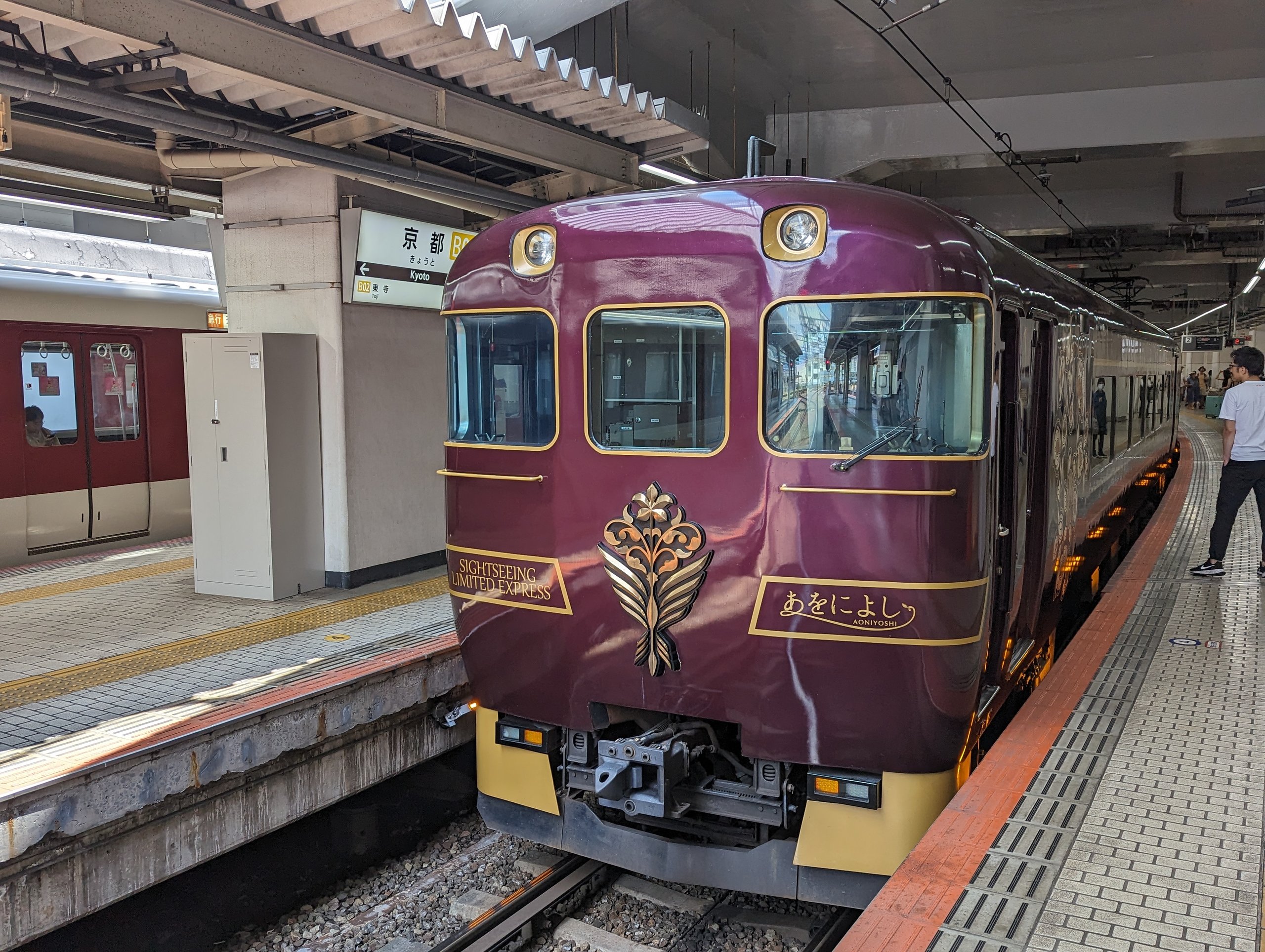 京都駅のホームに停まる、紫色の観光列車「あをによし」
