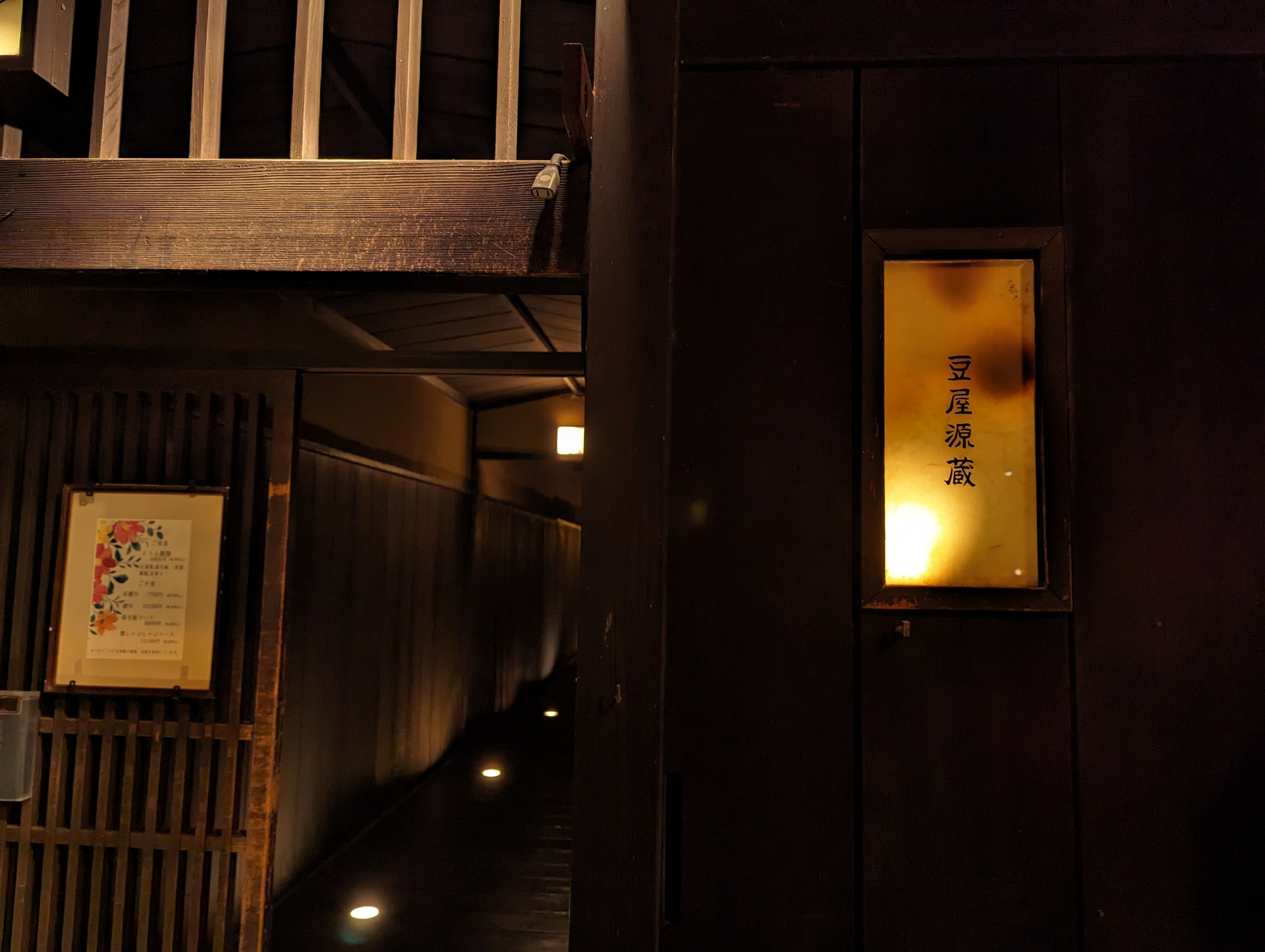 灯りに照らされた「豆屋源蔵」の店先