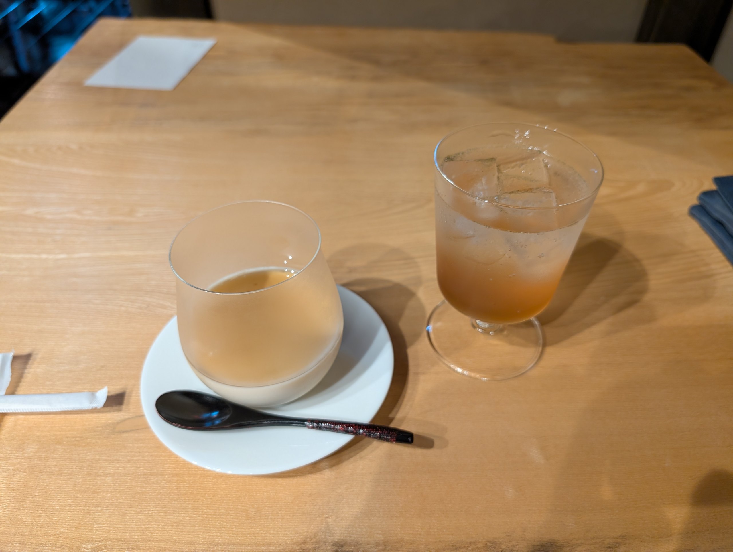 木のテーブルに置かれた、キハダのソーダとプリン