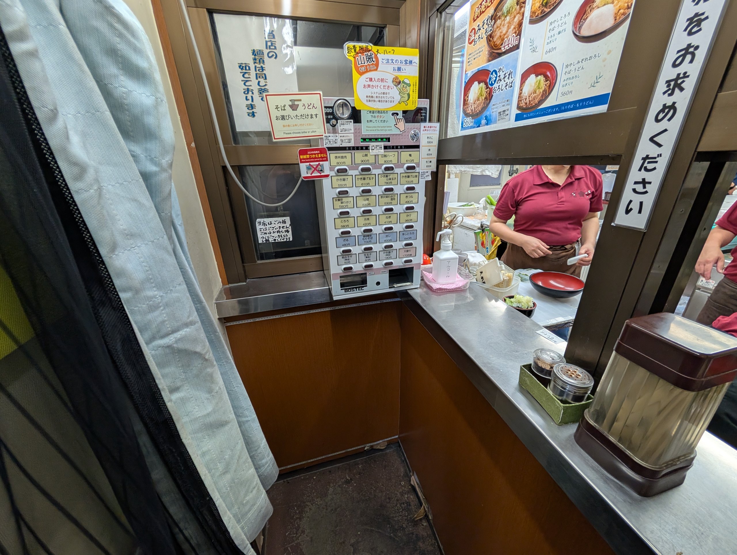 券売機とカウンターが並ぶ、せまい店の中