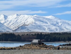 雪をかぶった山と森を背に、テカポ湖のほとりに建つ小さな石の教会