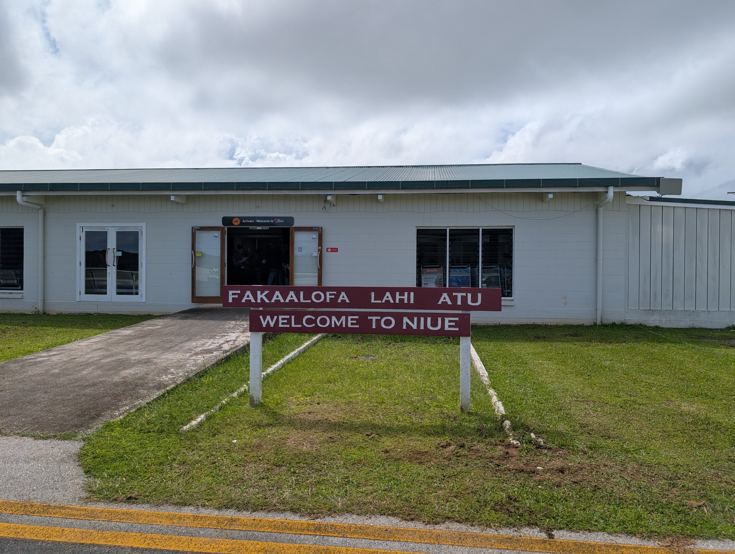 「FAKAALOFA LAHI ATU / WELCOME TO NIUE」の看板が立つ、ニウエの空港