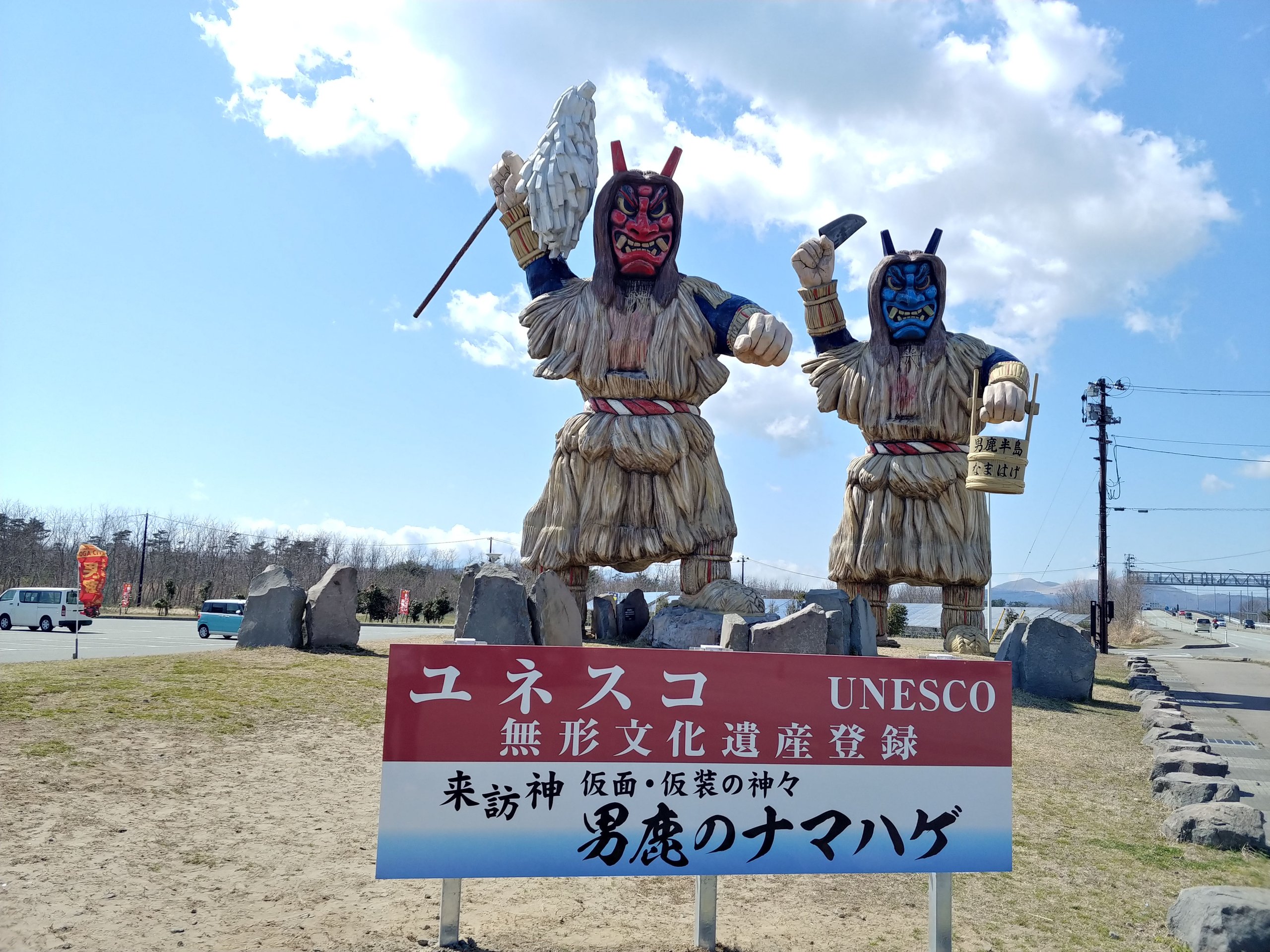 男鹿半島に立つ2体の大きななまはげ像と、ユネスコ無形文化遺産登録の看板