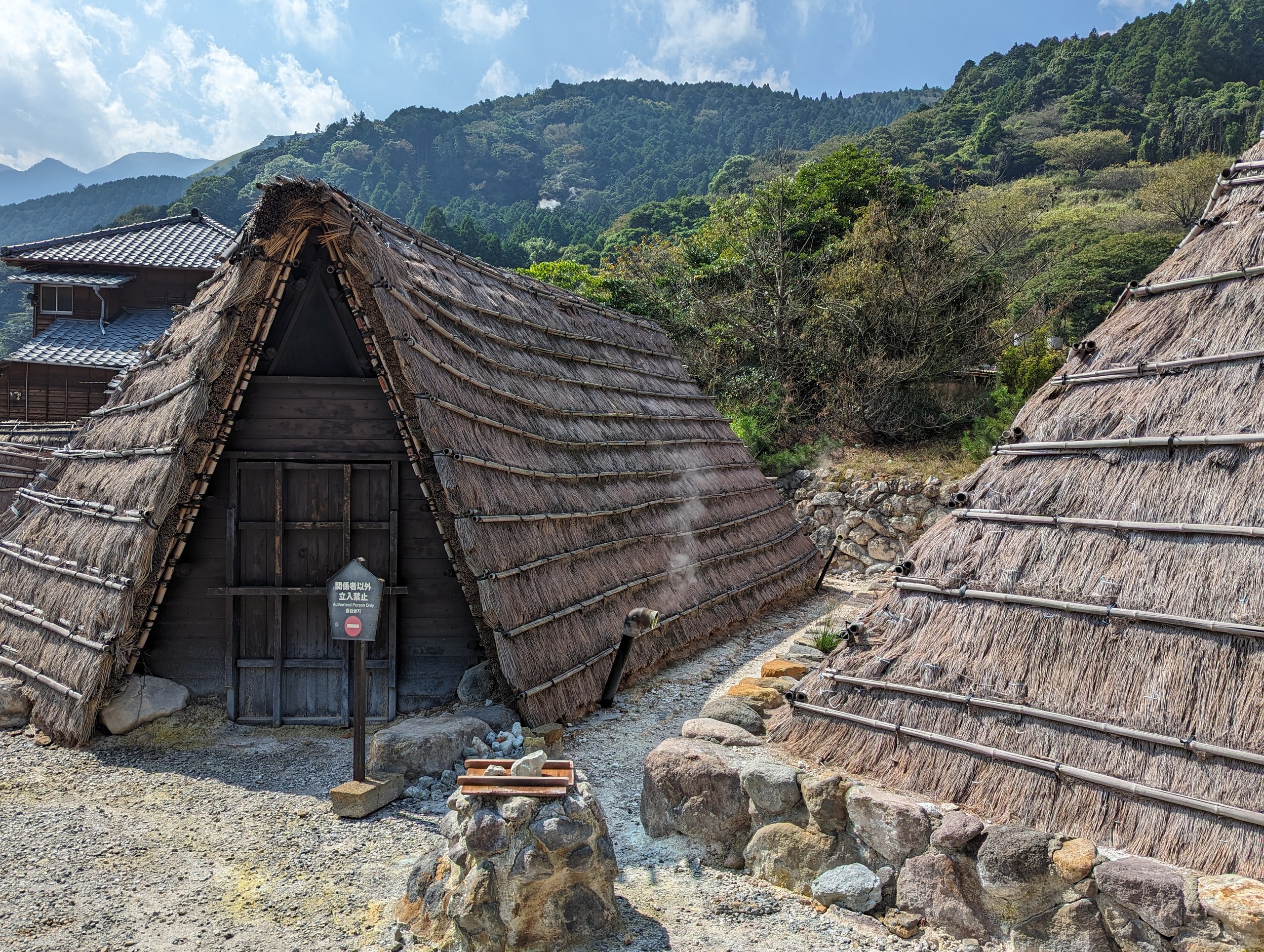 岩の上に建ち並ぶ、三角屋根のわら葺き小屋
