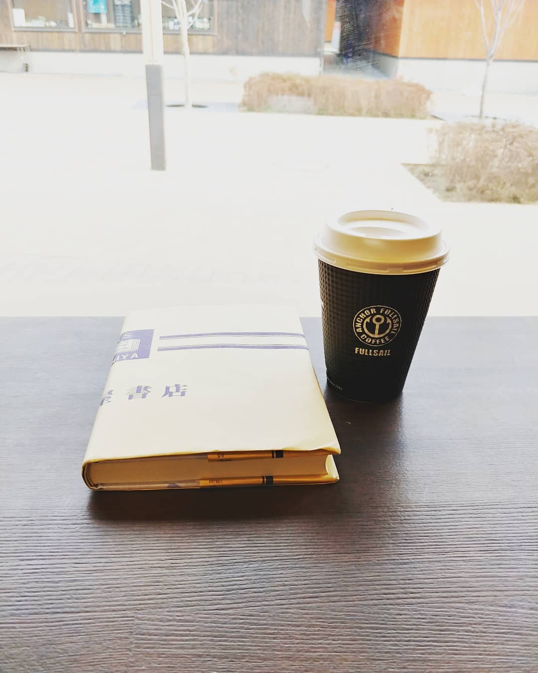 コーヒーと本を置いた、女川のカフェのテーブル