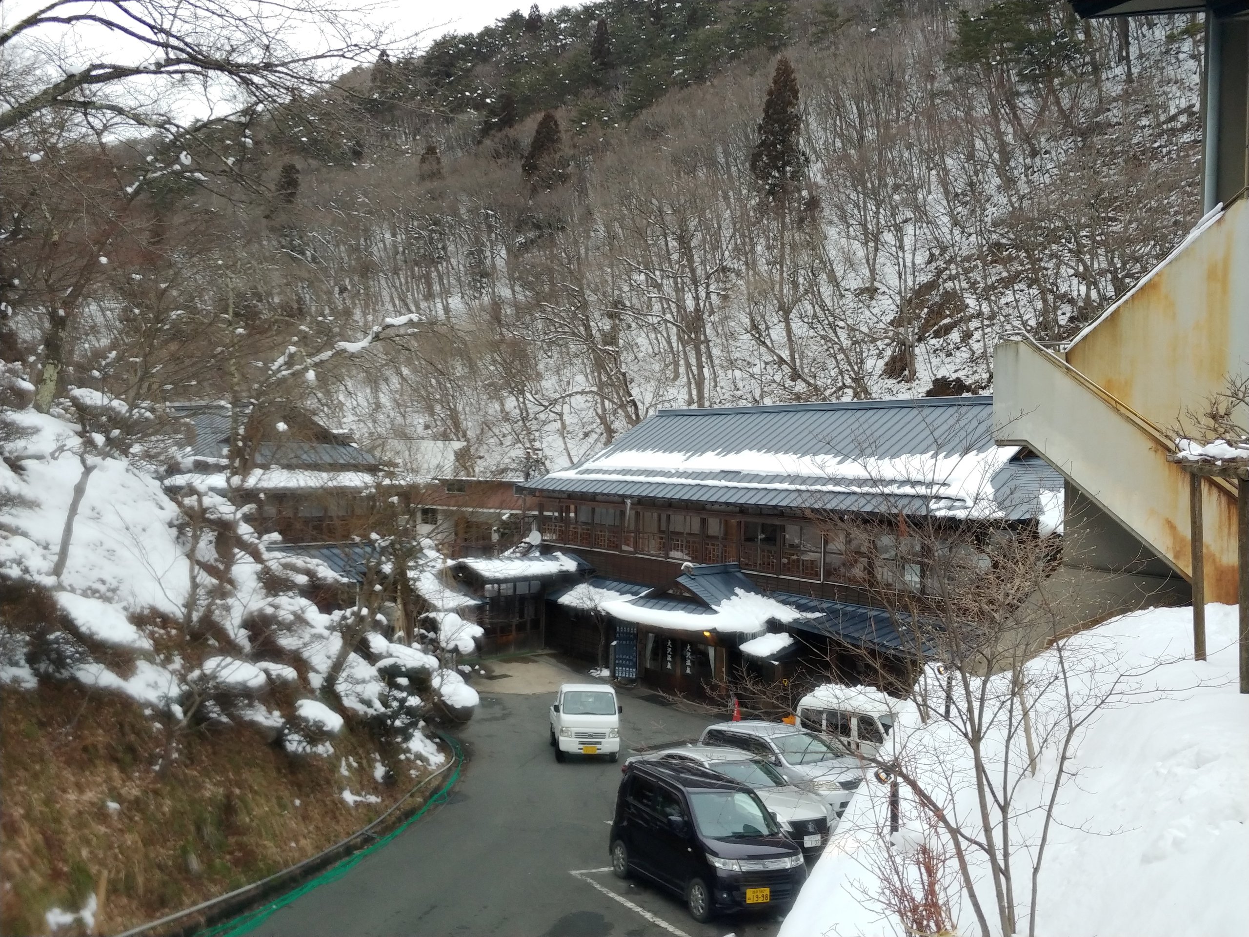 雪の谷間に並ぶ湯治屋の屋根
