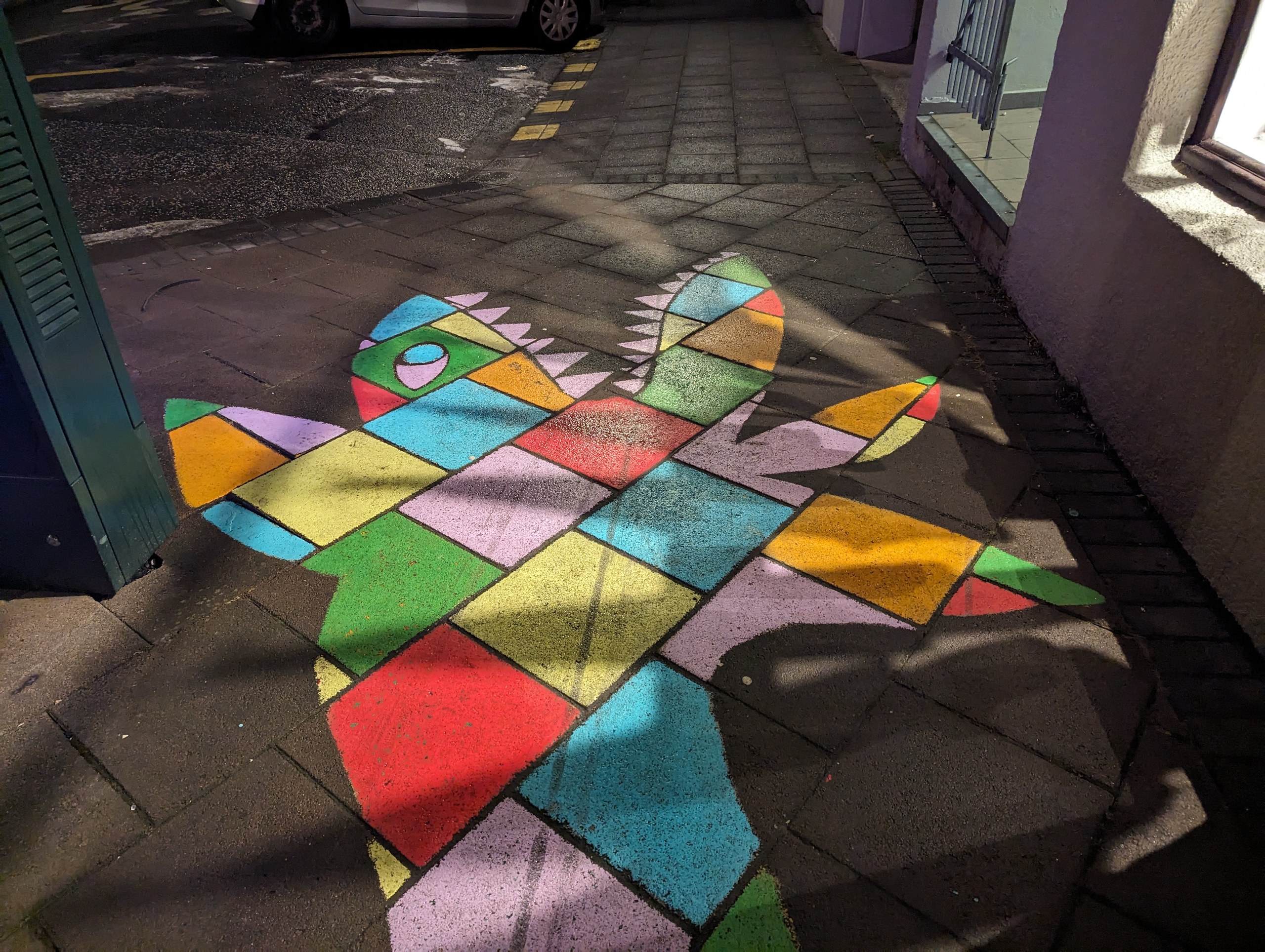 歩道に描かれた、カラフルなタイル模様の絵