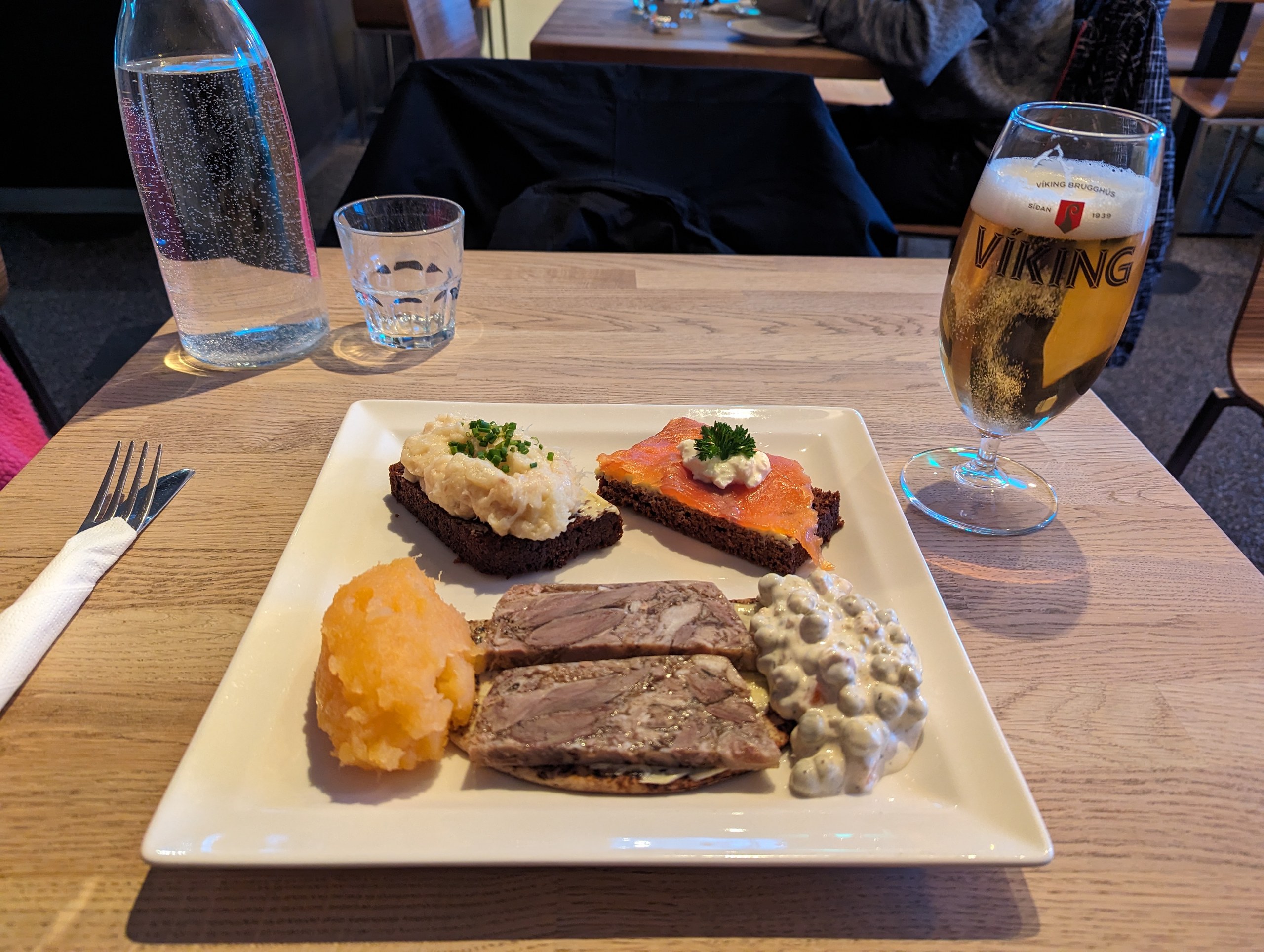 黒パンや干し魚がのった、アイスランド料理の盛り合わせとビール