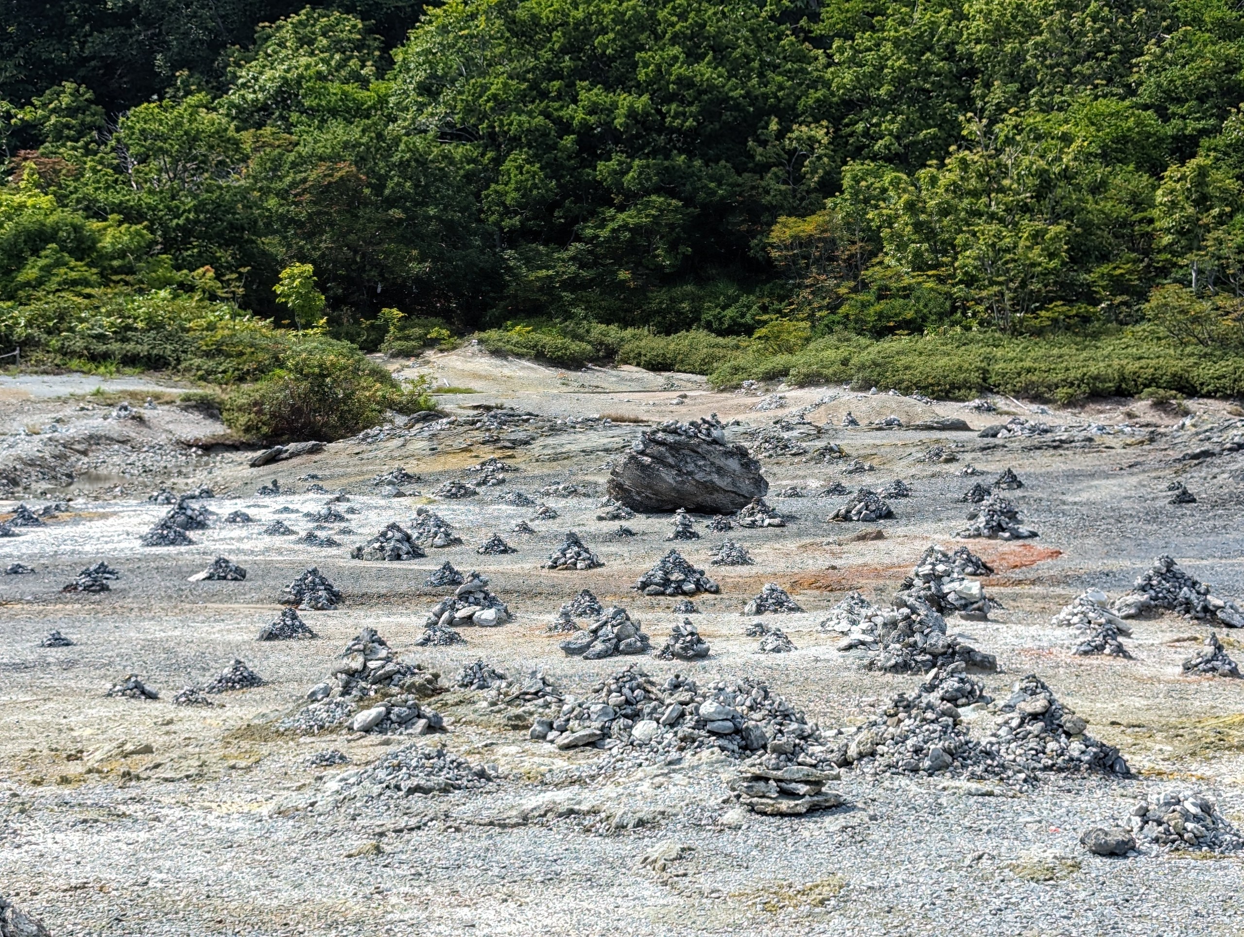 白い地面のあちこちに積まれた、小さな石の山