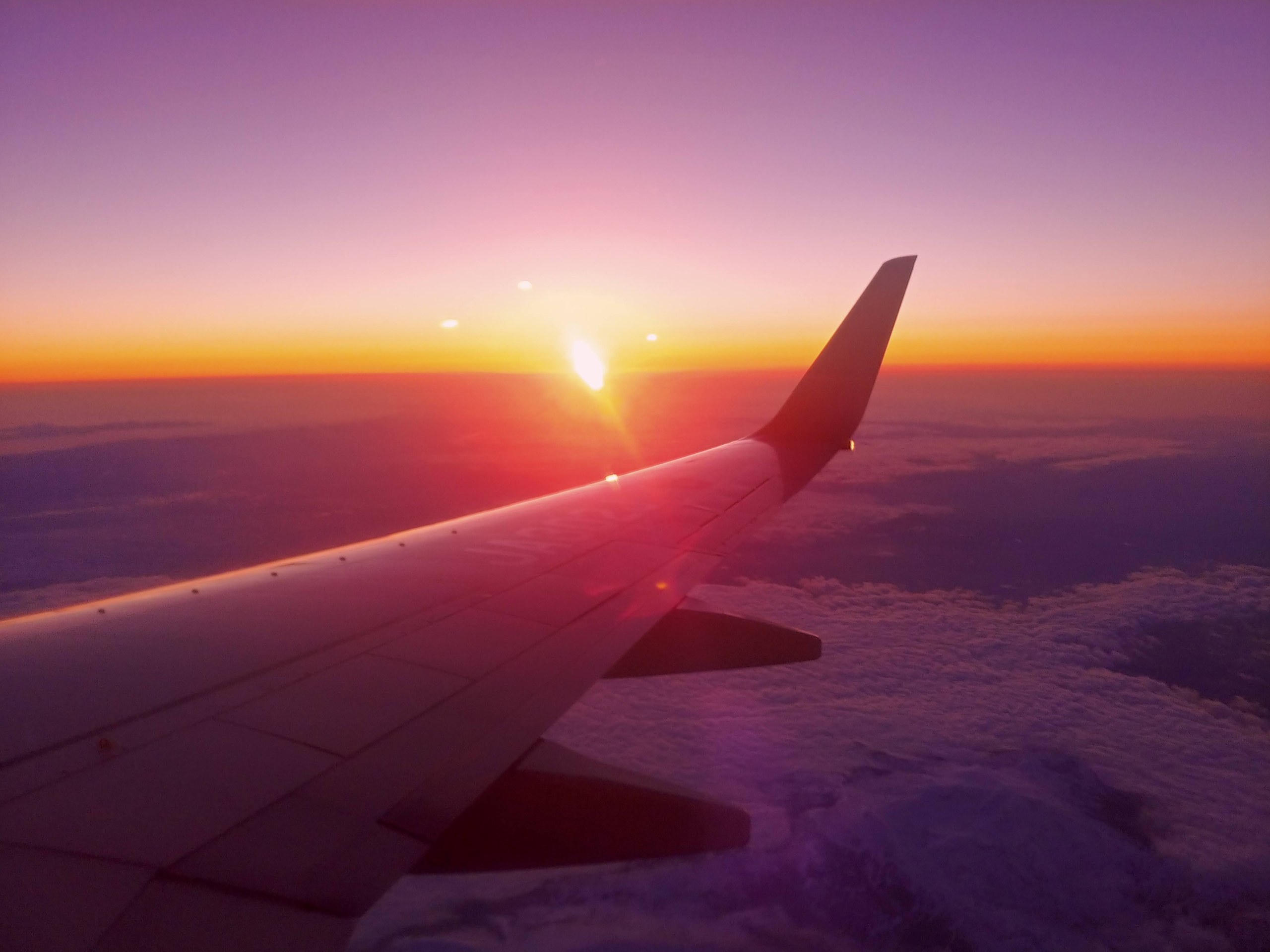 雲の上の夕焼けと飛行機の翼
