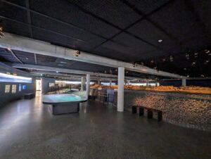 暗い展示室の中央に残る、昔の家の石の土台