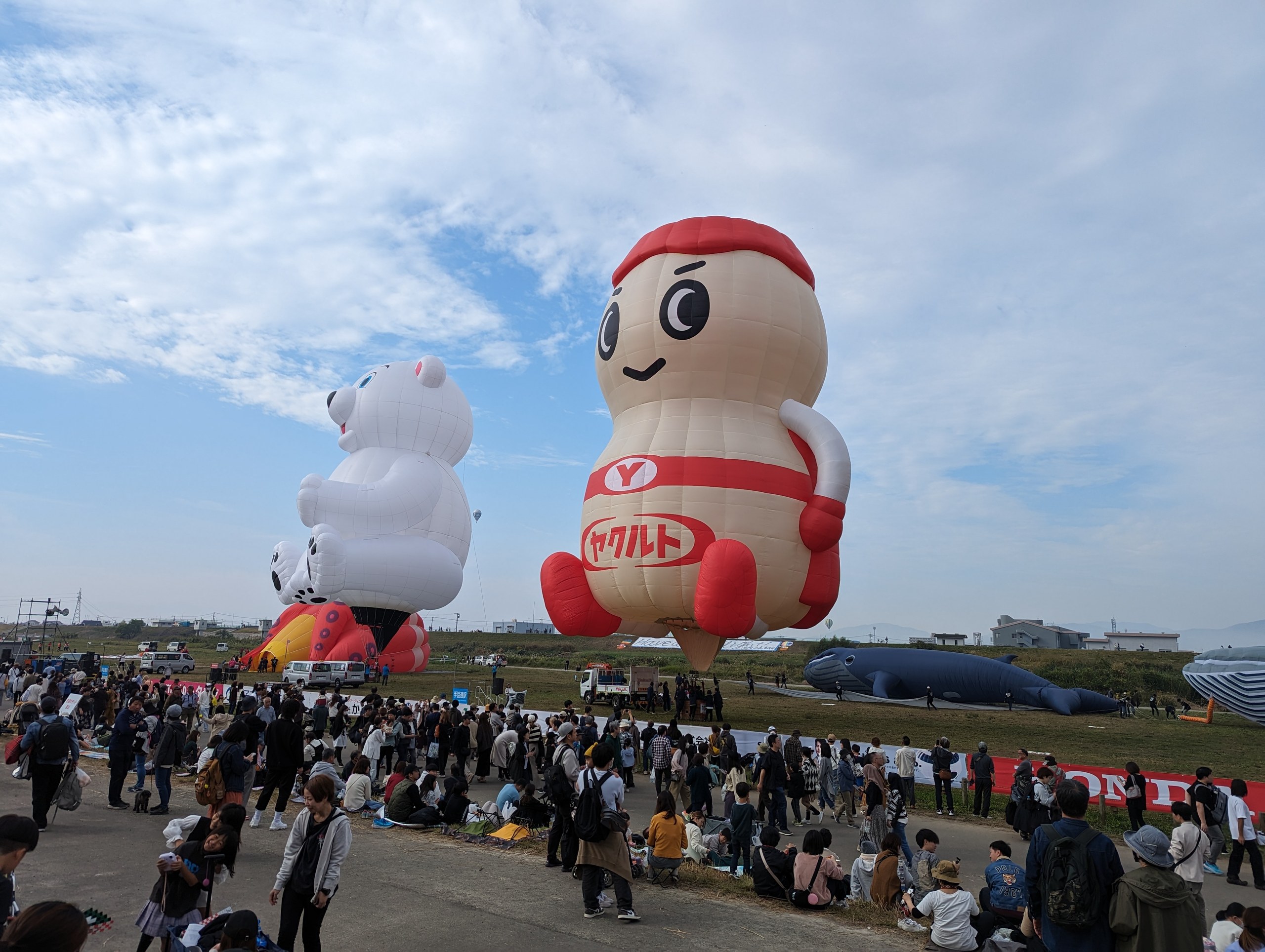 河川敷に立つ、大きなキャラクターの形のバルーン