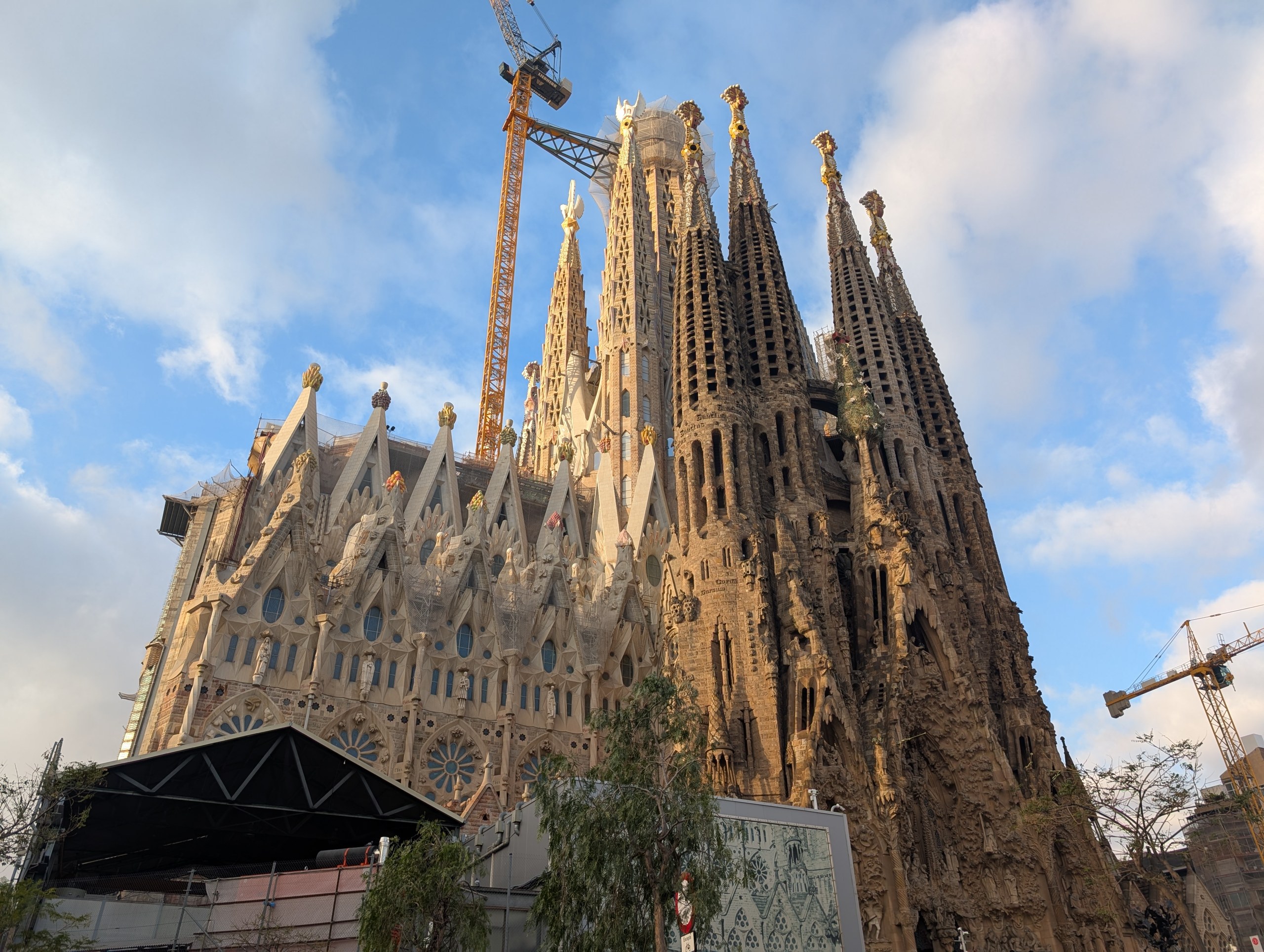 元日の朝のサグラダ・ファミリア。彫刻に覆われた塔とクレーン、白い雲の空