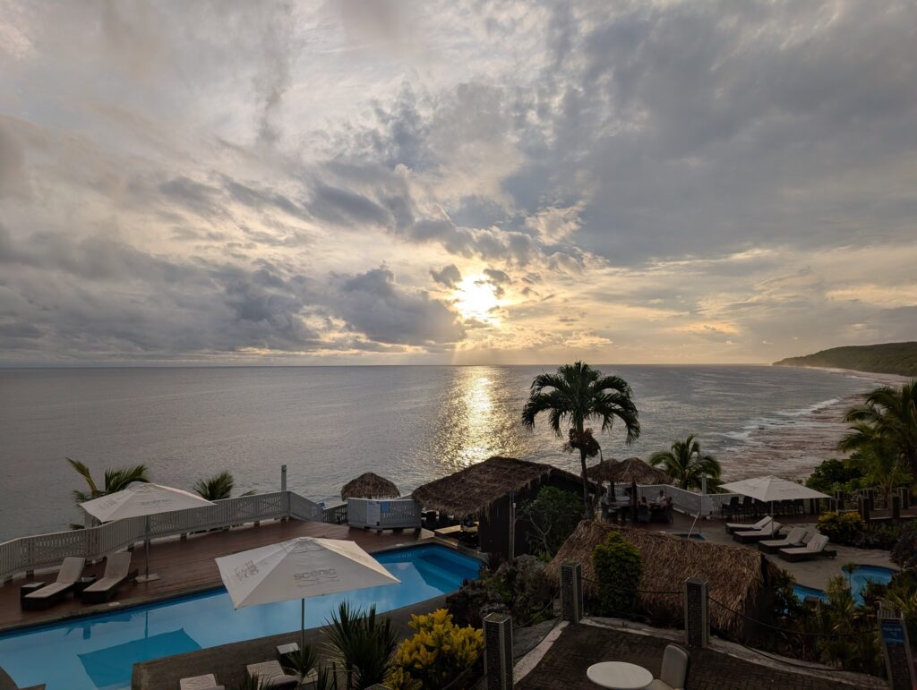 プールと海の向こうに沈んでいく夕日