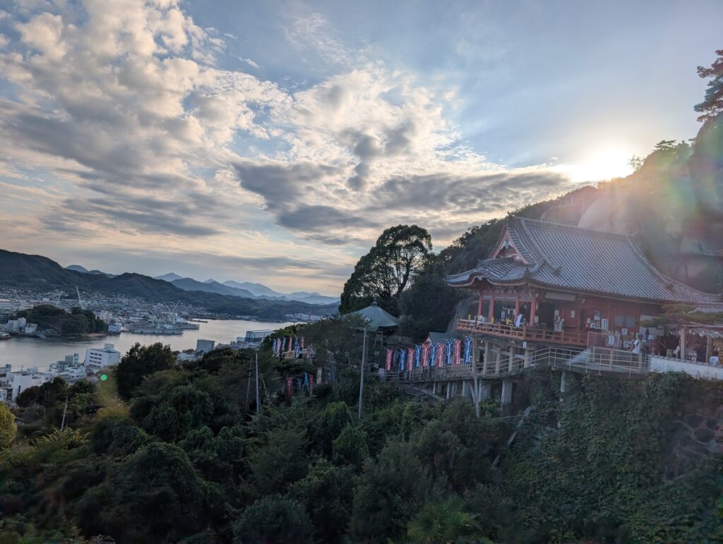 夕日に照らされる雲と、崖の上の千光寺の本堂