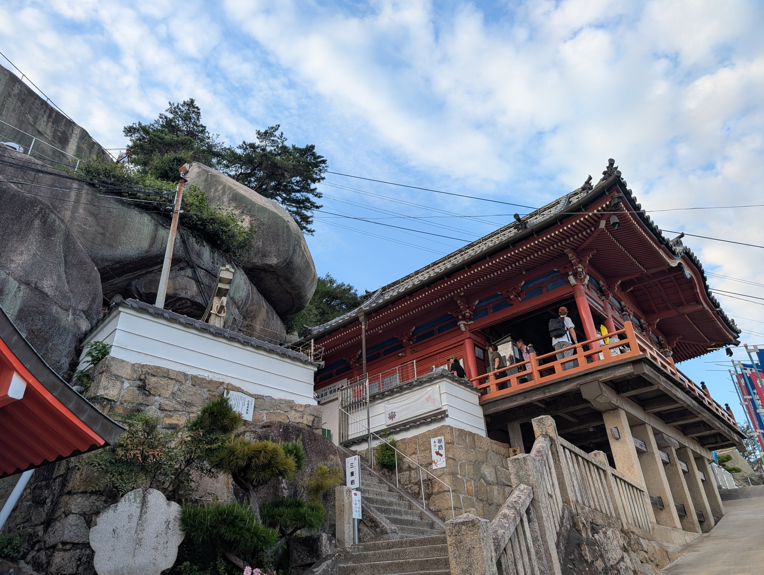 大きな岩の横に建つ、朱色の千光寺の本堂