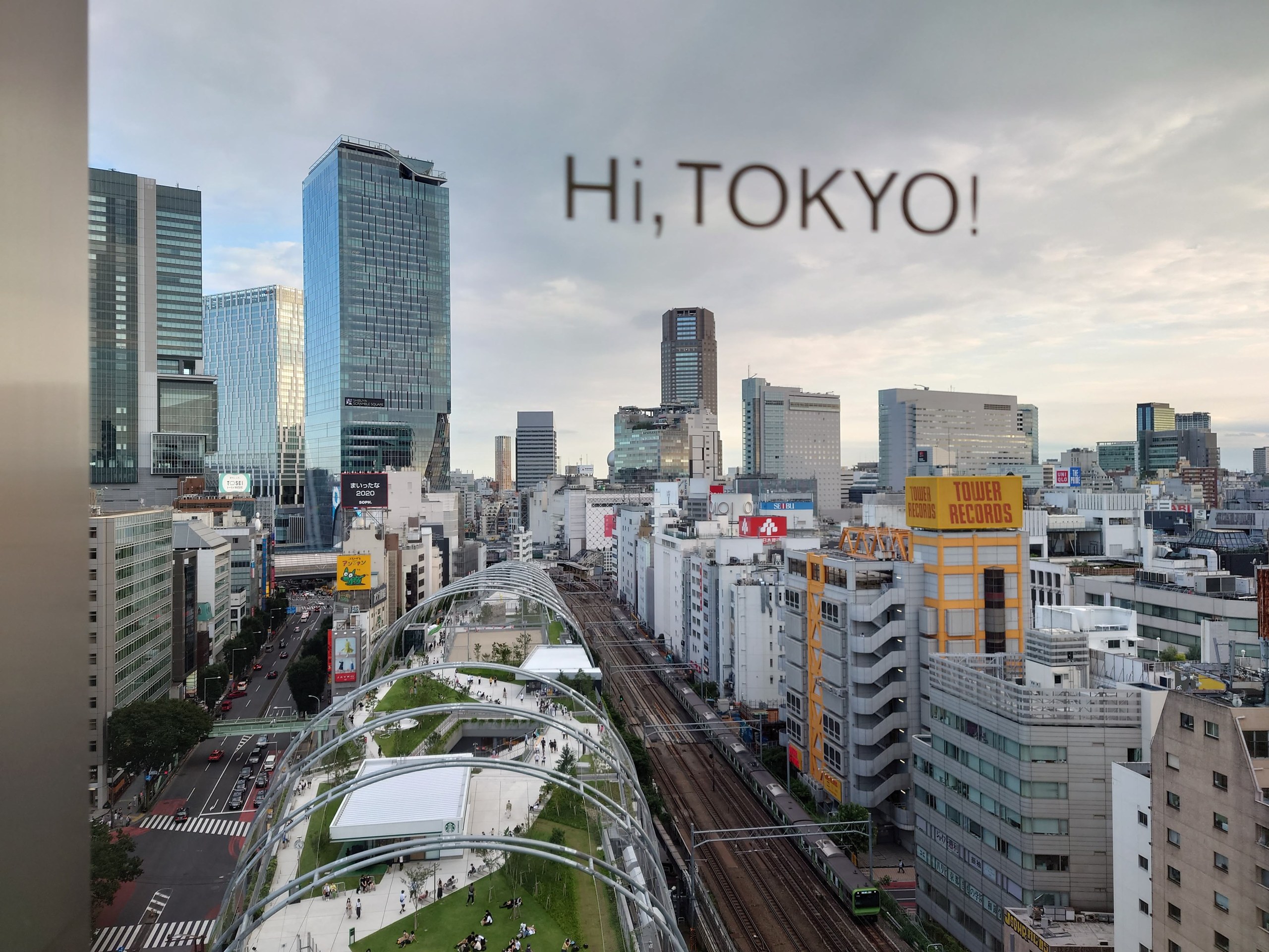 窓の「Hi, TOKYO!」の文字と渋谷の街
