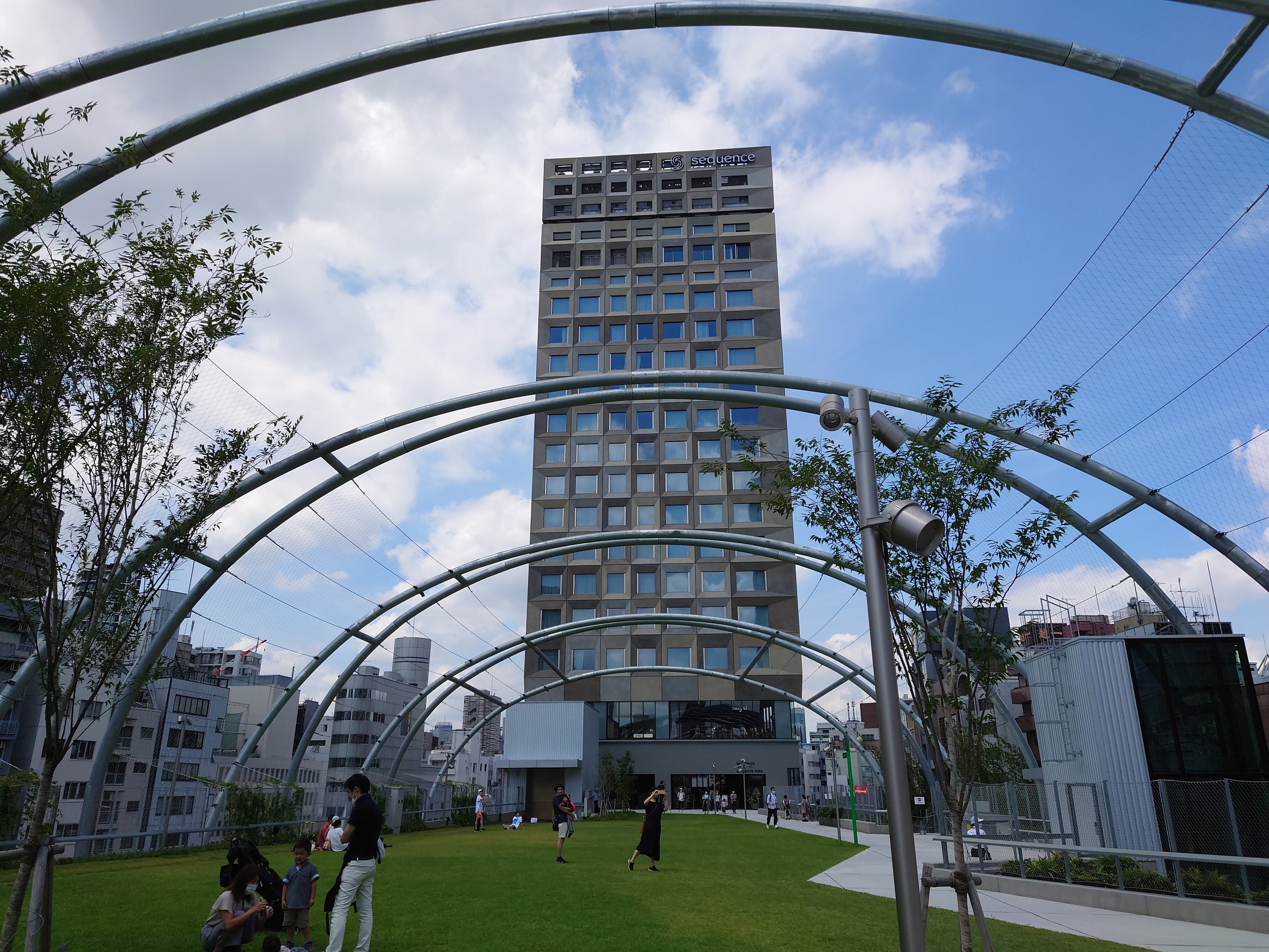 芝生の向こうに建つsequence MIYASHITA PARK