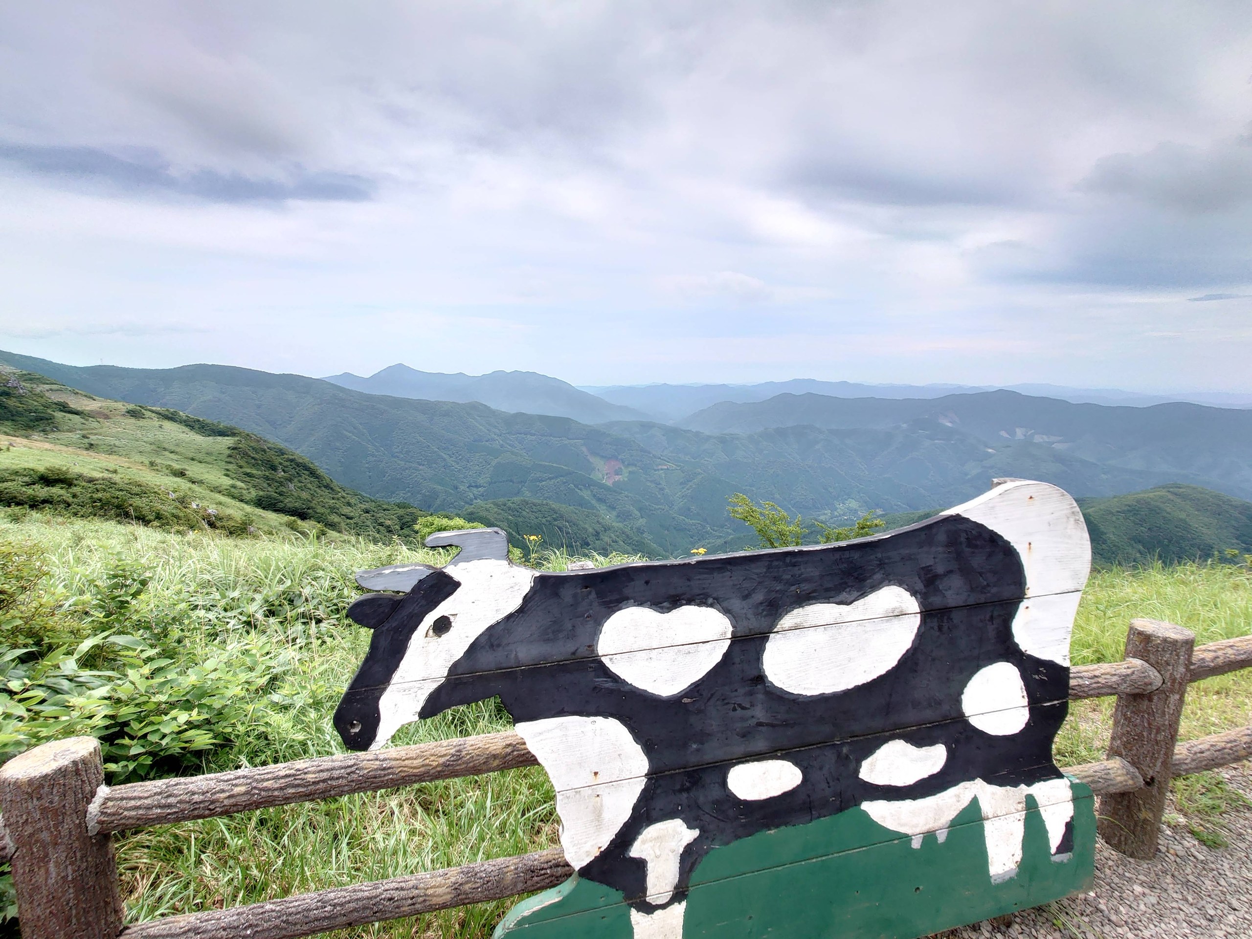 牛の形をした看板と、その先の山並み