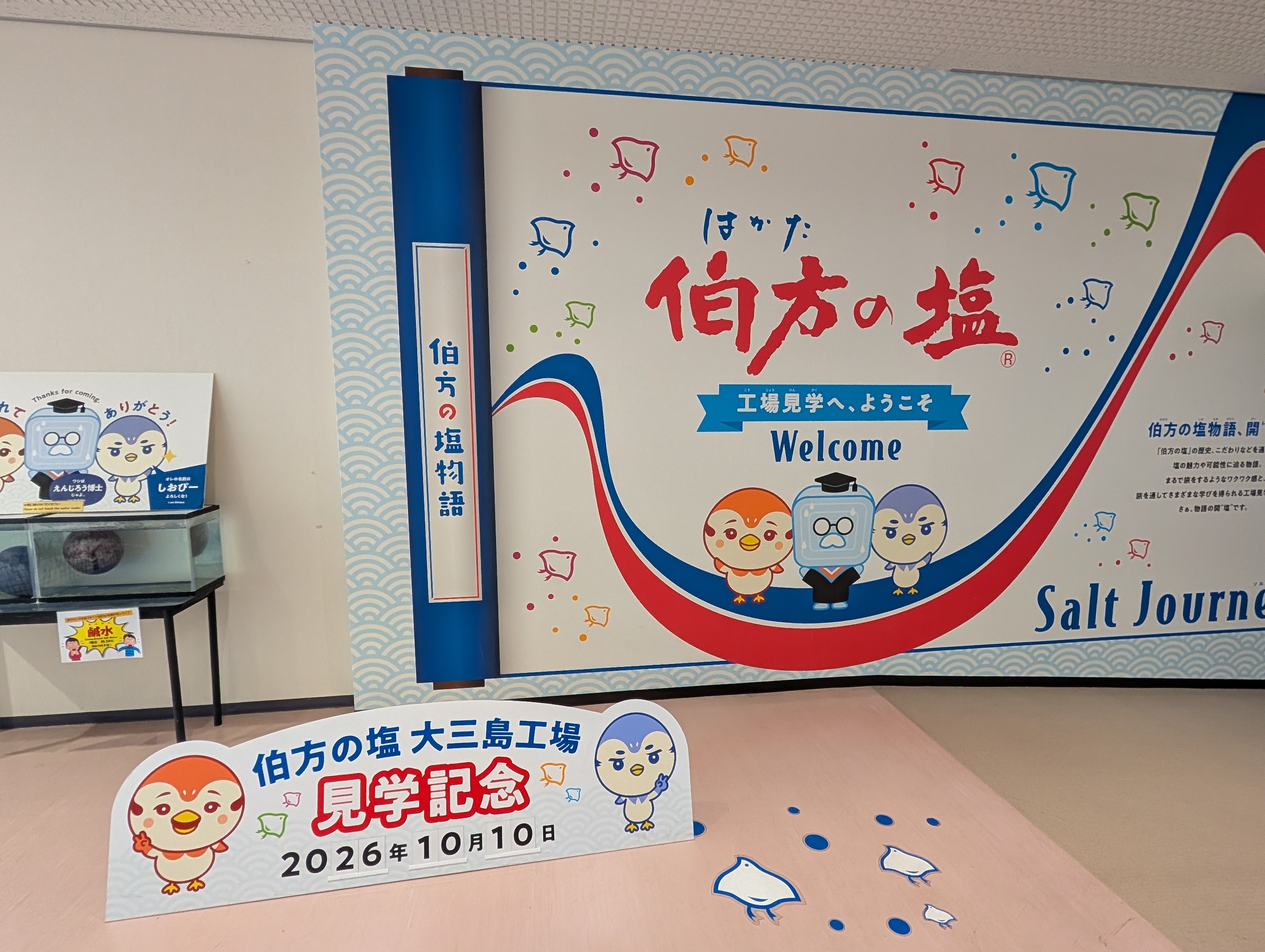 「伯方の塩 大三島工場 見学記念 2026年10月10日」の札と、工場見学の案内