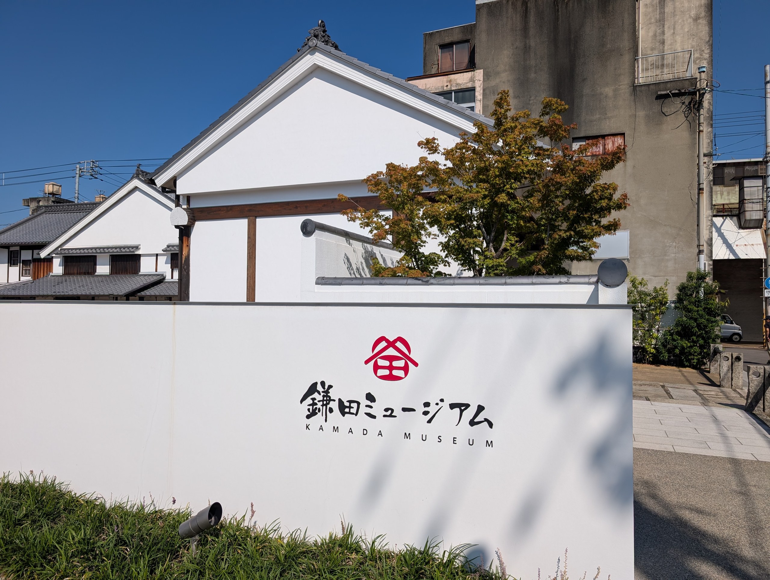白壁の建物の前の「鎌田ミュージアム」の看板