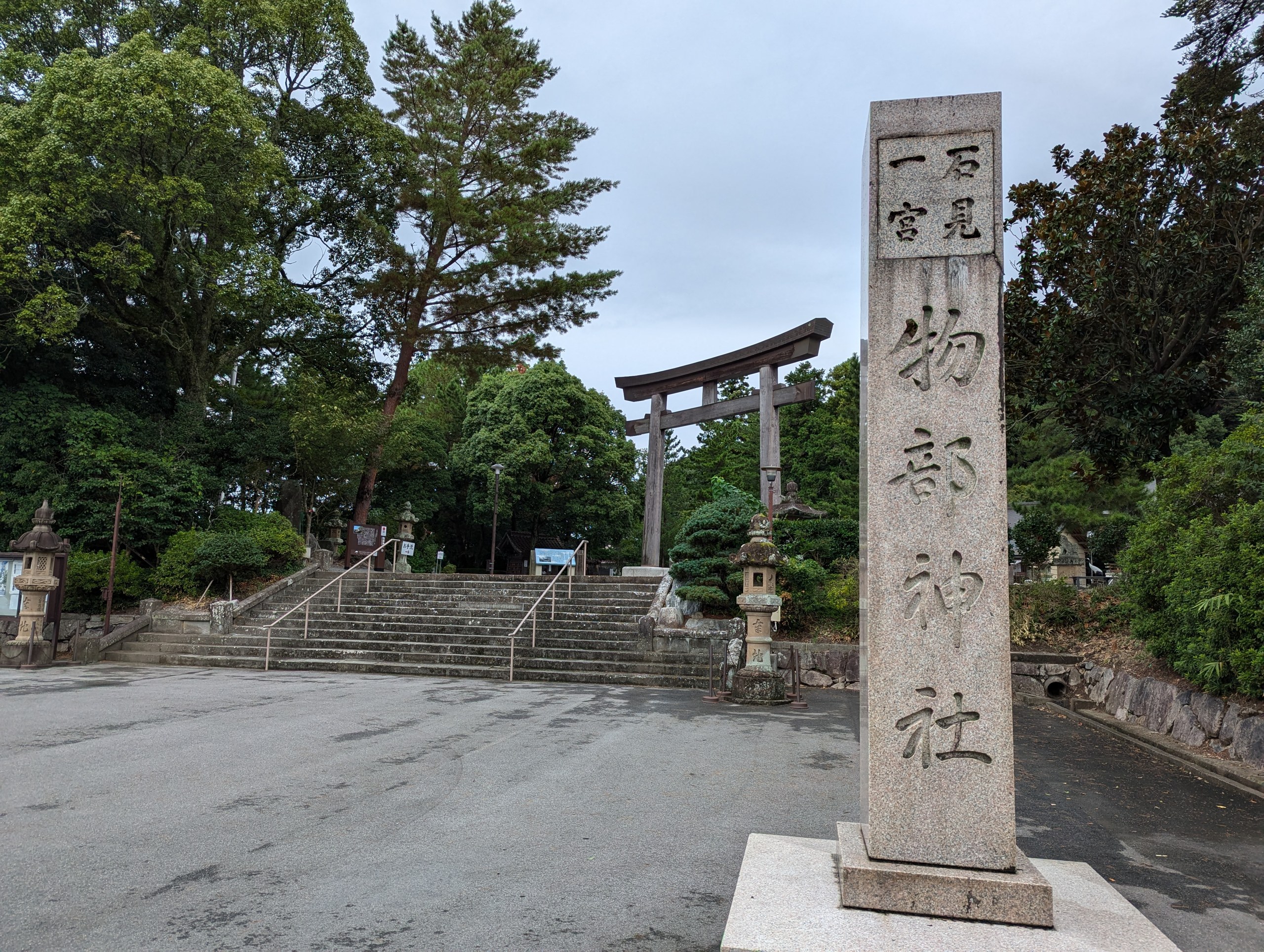 「石見一宮 物部神社」と刻まれた社号標と、奥の石段と鳥居