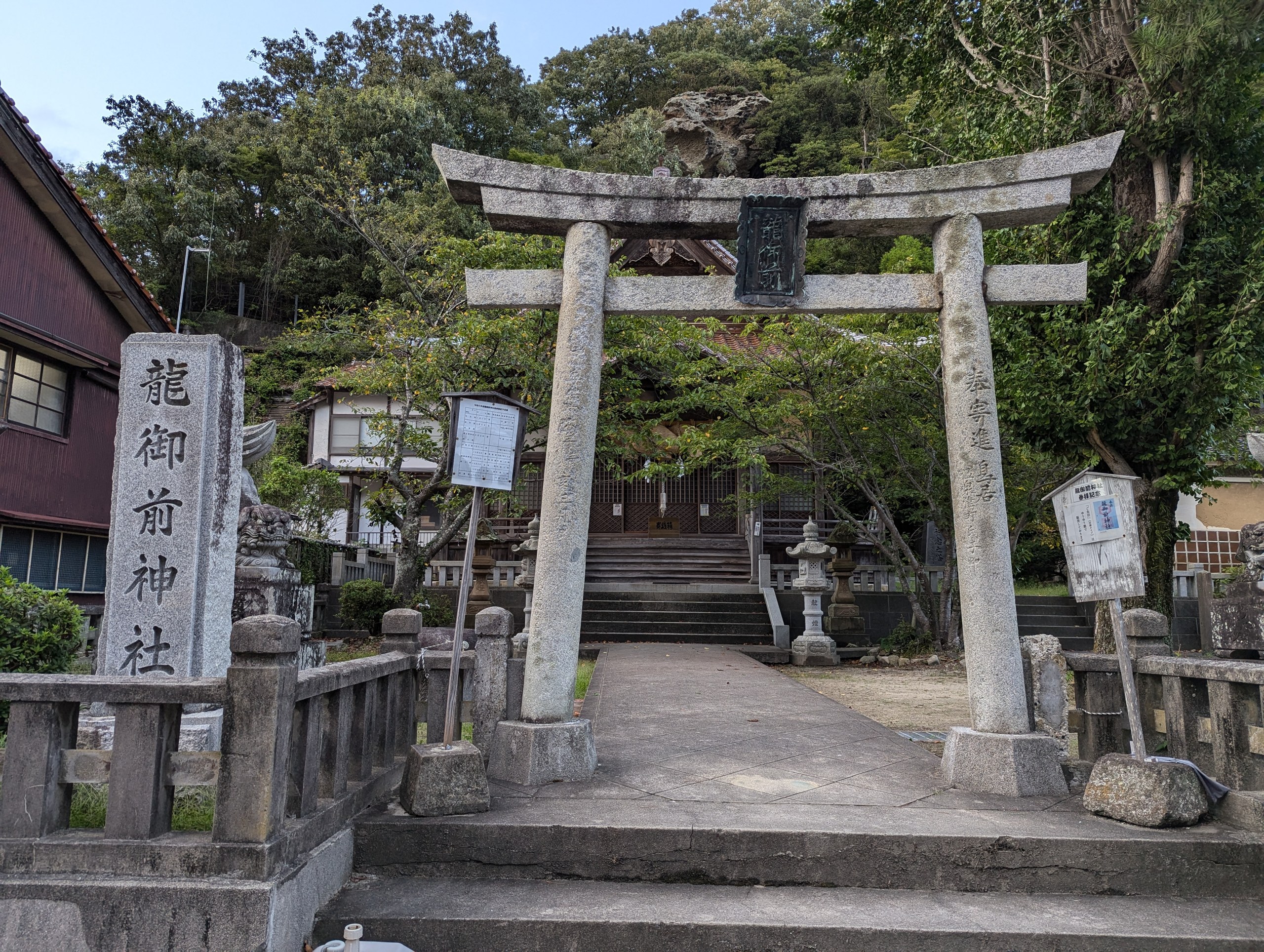 「龍御前神社」の社号標と石の鳥居、奥の石段