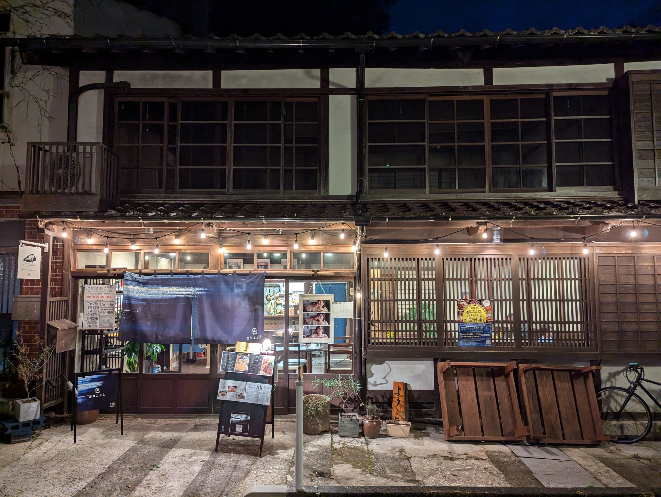 夜の温泉津温泉で、紺色の暖簾が掛かった古民家の「色 shiki」の店先