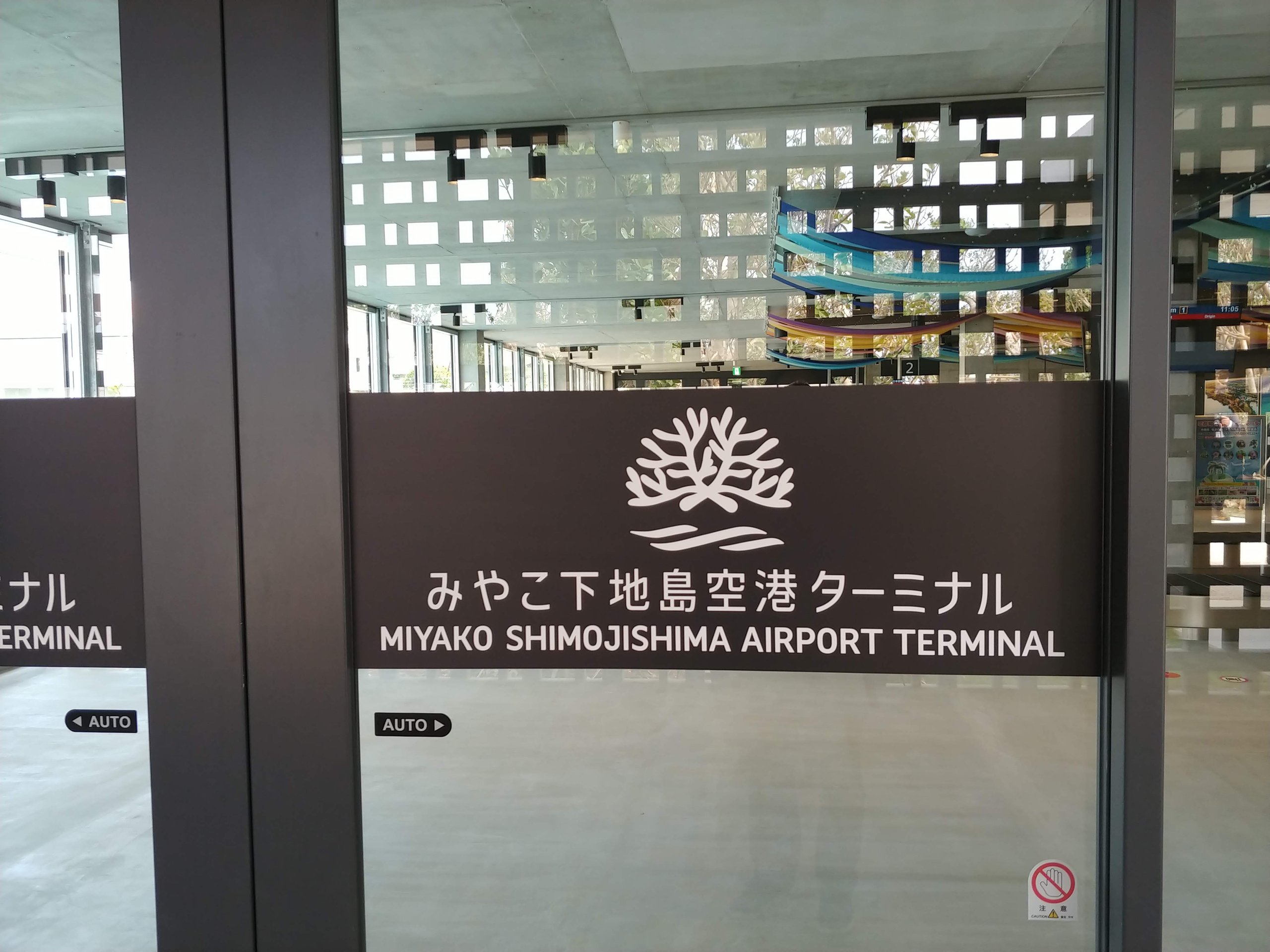 「みやこ下地島空港ターミナル」の看板があるガラスの入口