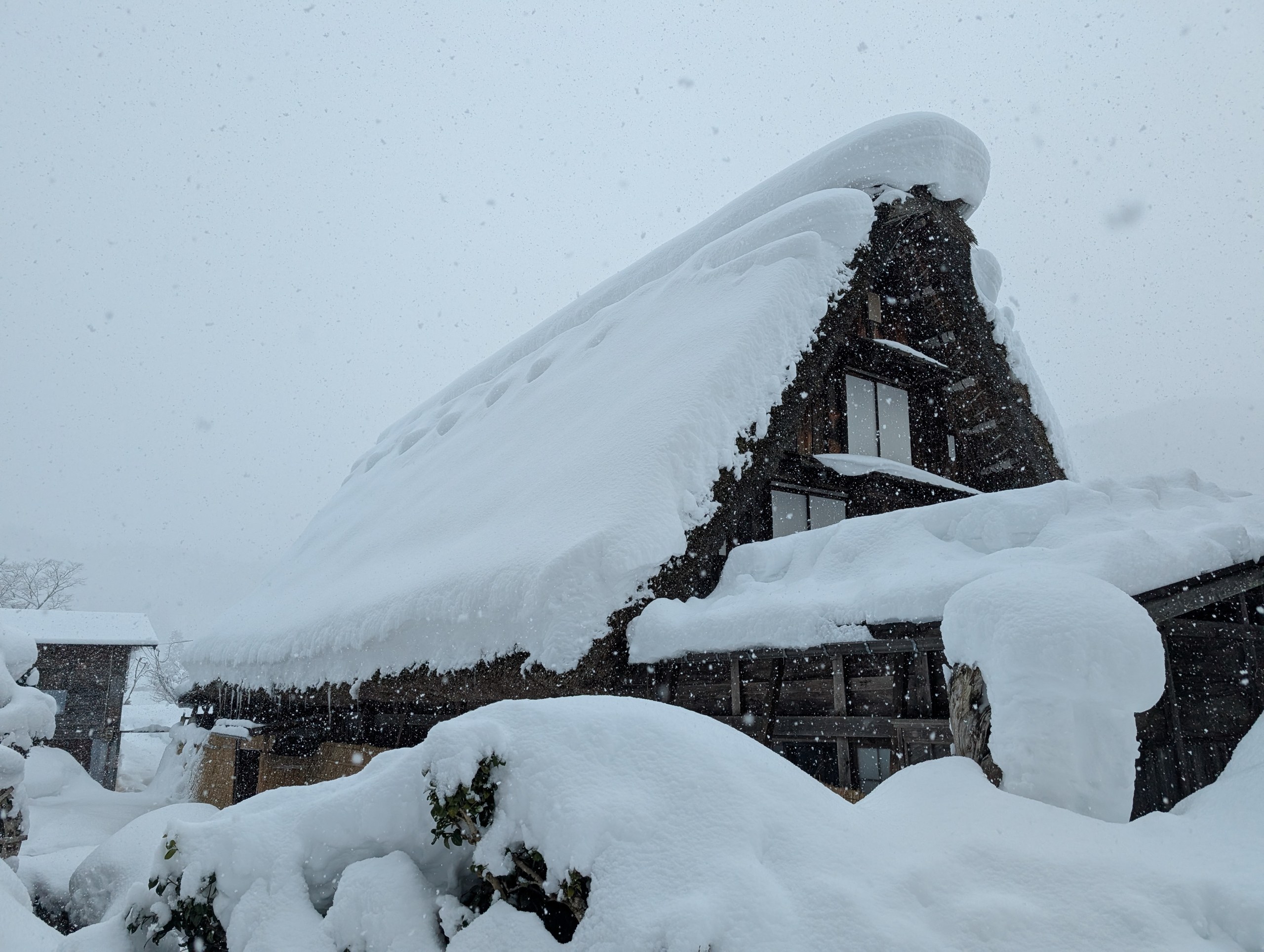 雪にすっぽり覆われた、合掌造りの家