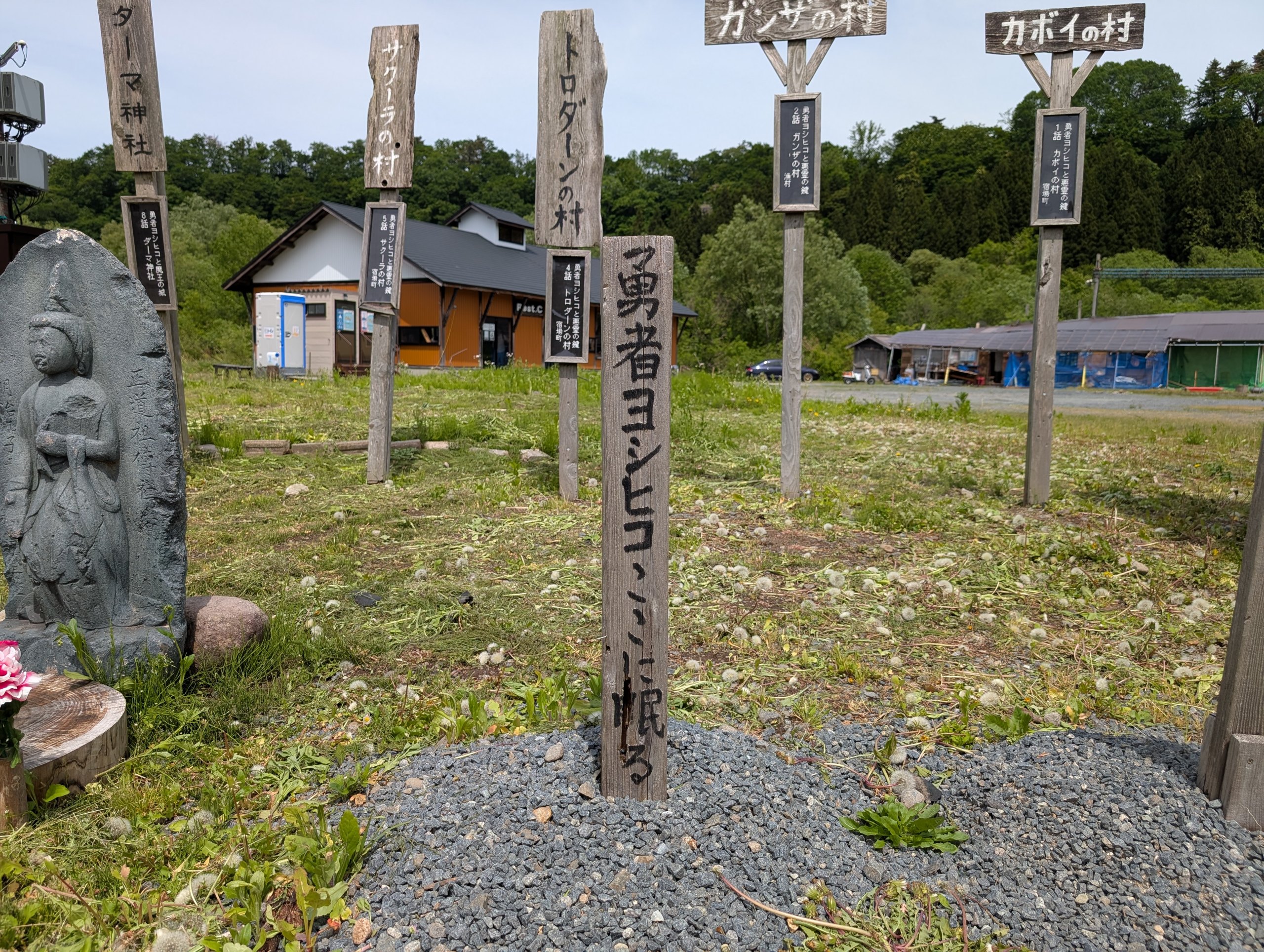 「勇者ヨシヒコ」と書かれた木の墓標とお地蔵さま