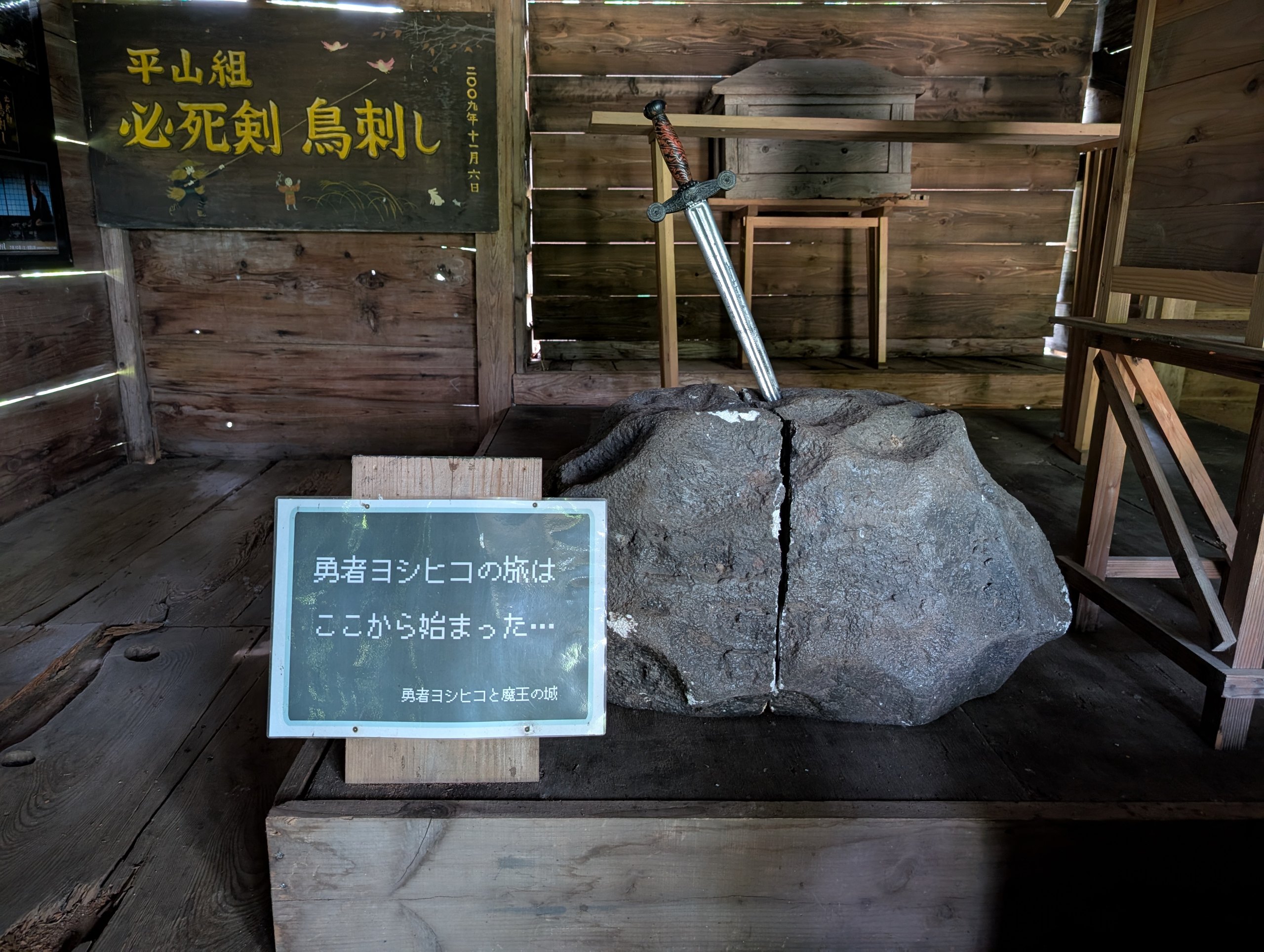 岩に刺さった剣と「勇者ヨシヒコの旅はここから始まった…」の札