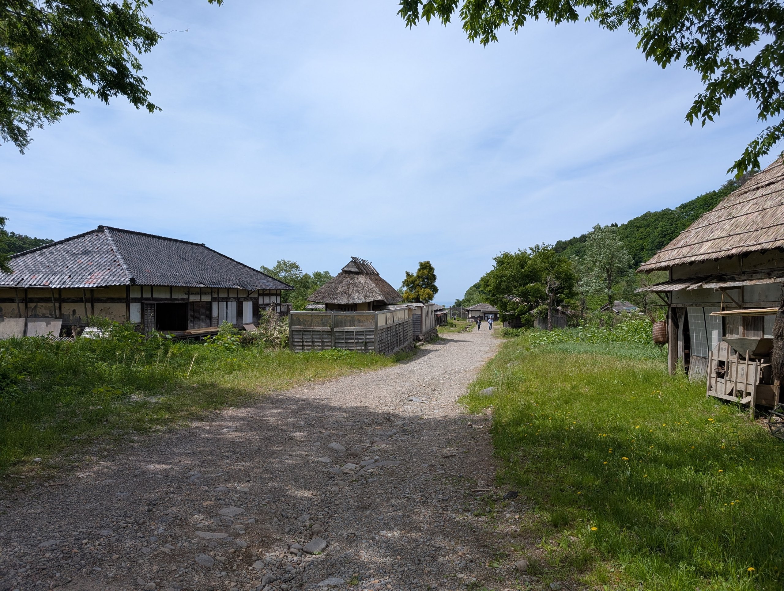 かやぶき屋根や瓦屋根の家が並ぶ、セットの村の道