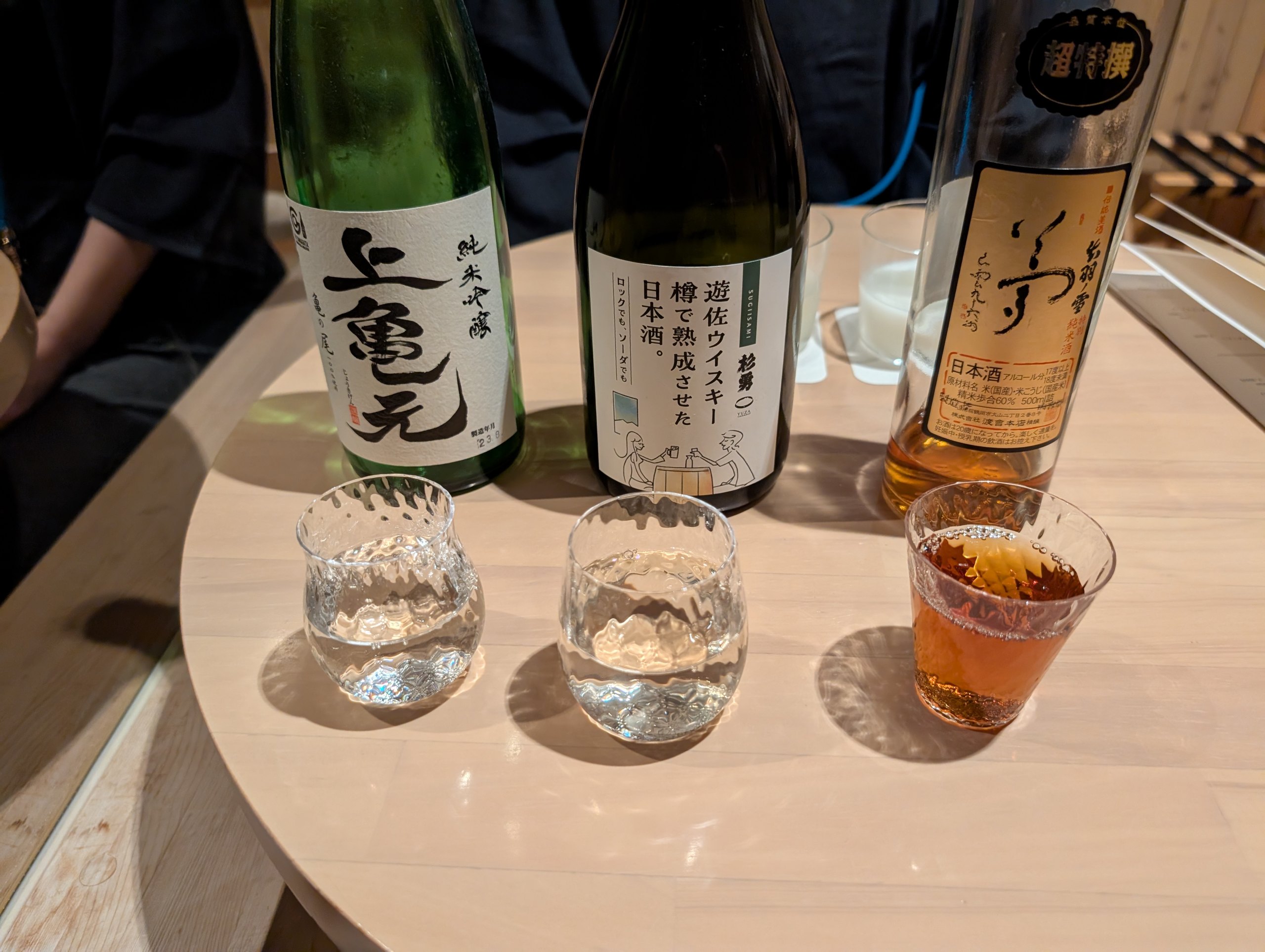 「上喜元」などの瓶と、小さなグラスに注がれたお酒
