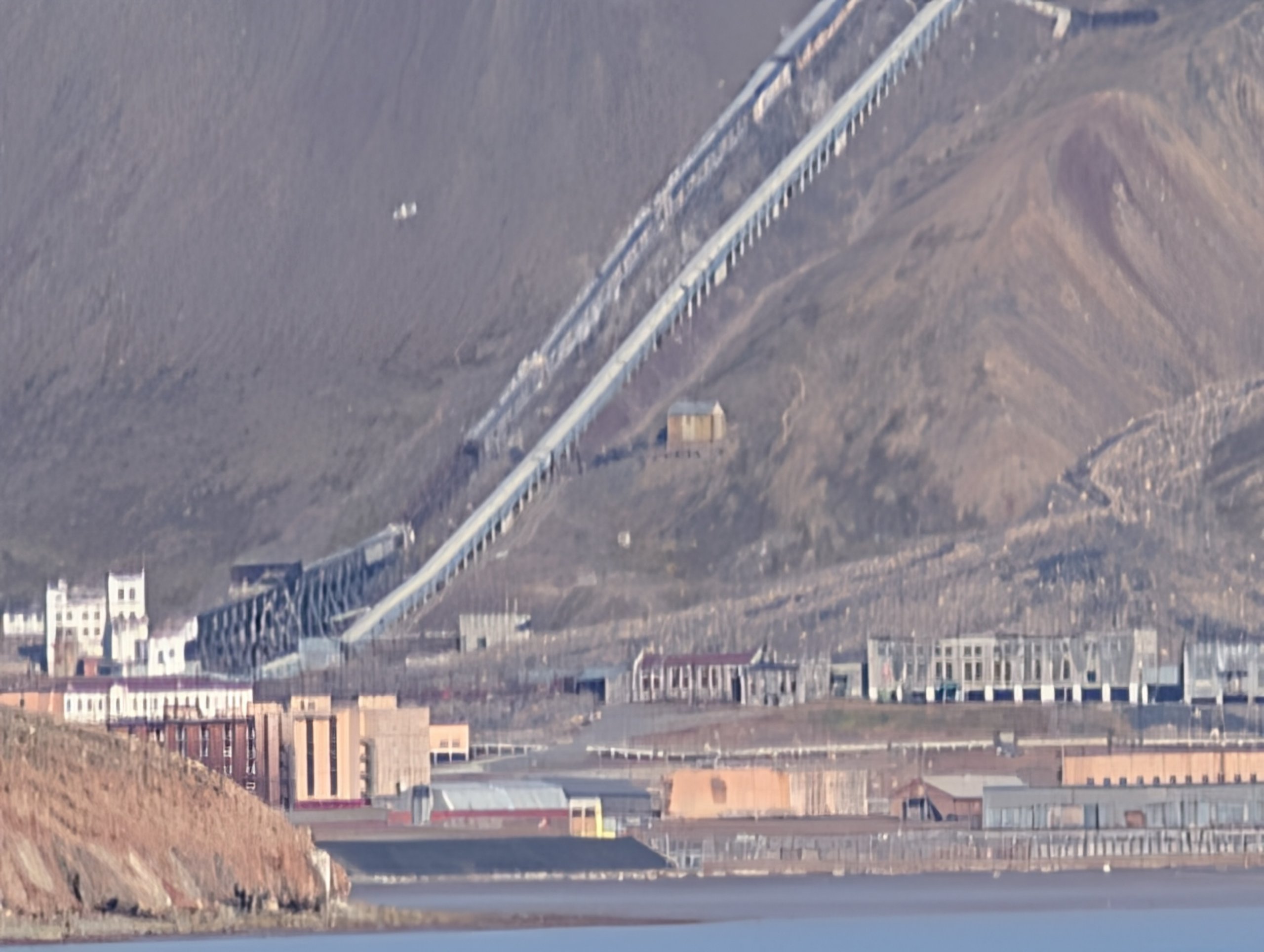 山のふもとに並ぶピラミデンの建物と、斜面を走る古い設備
