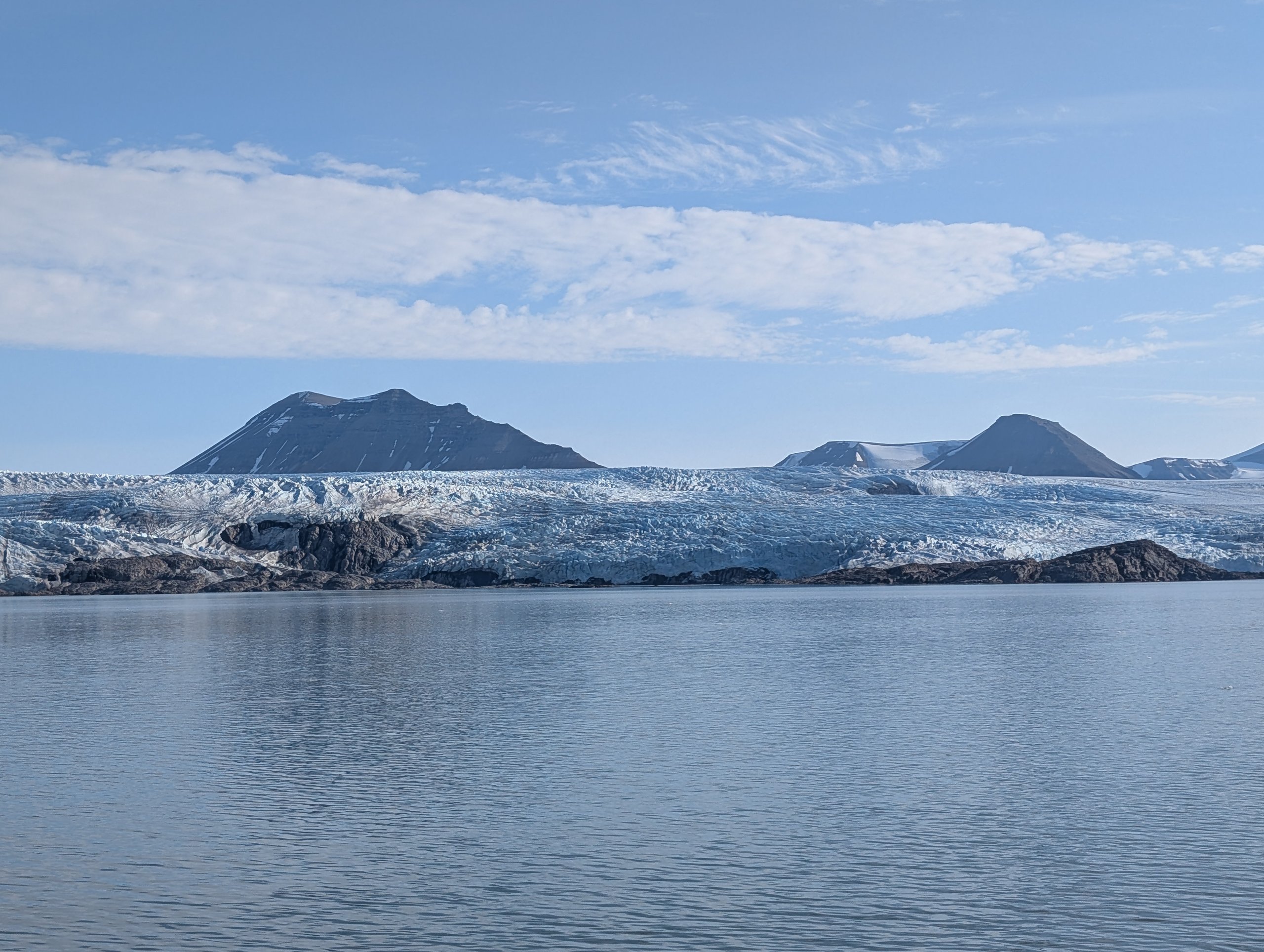 青空の下、海の向こうに広がるノルデンショルド氷河