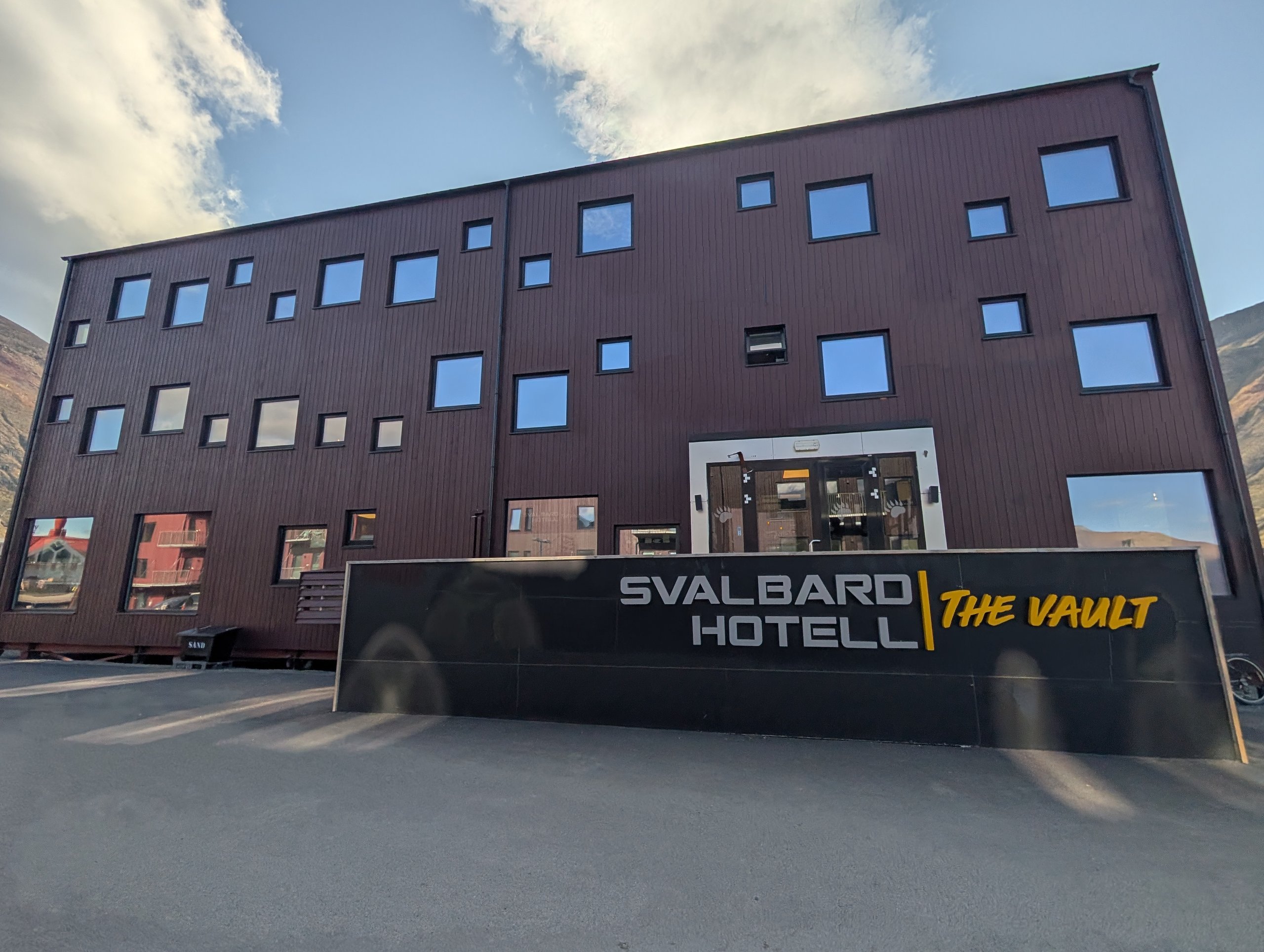 「SVALBARD HOTELL THE VAULT」の看板と、四角い窓が並ぶ建物