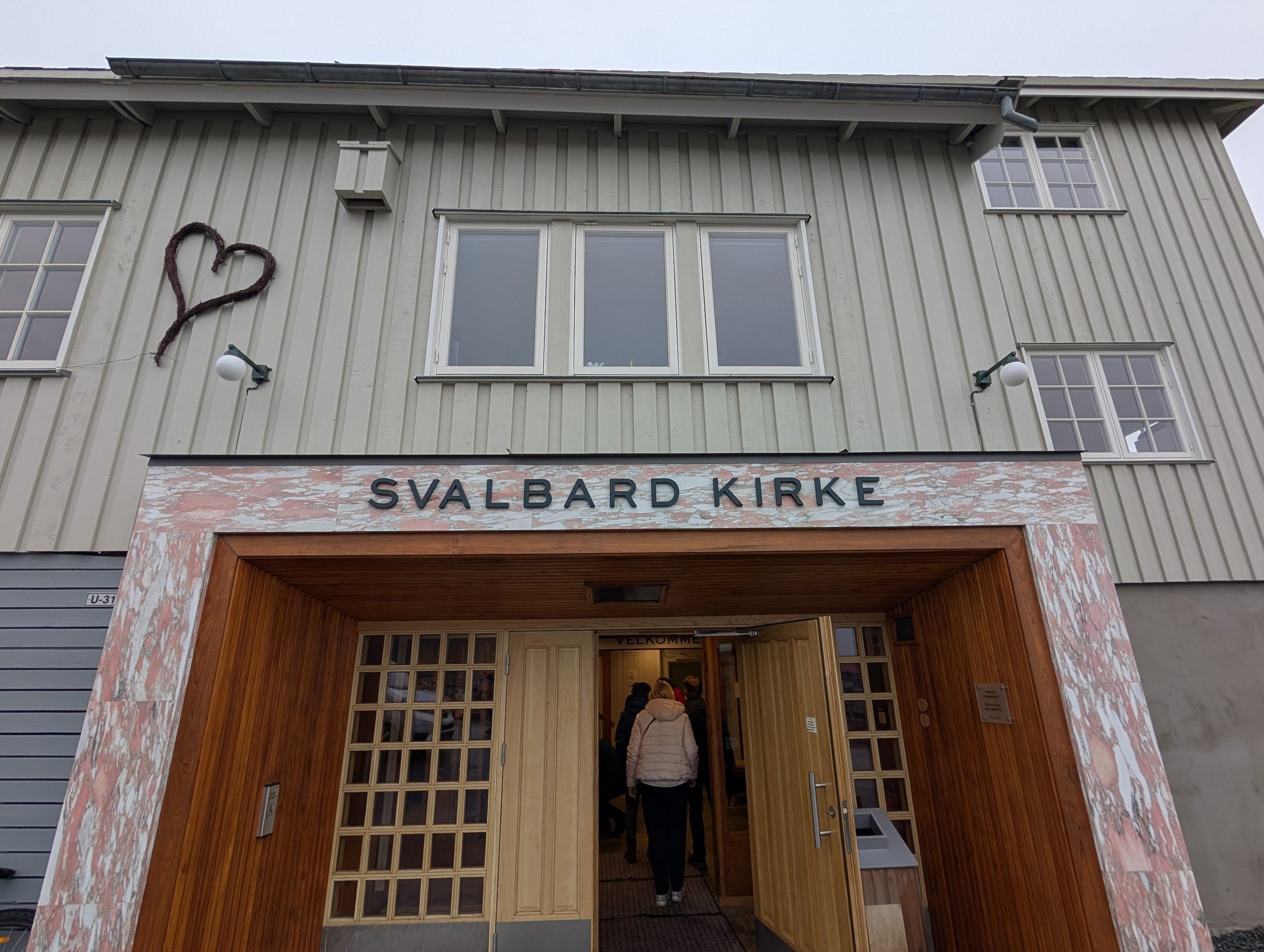 「SVALBARD KIRKE」の文字が掲げられた、教会の入口