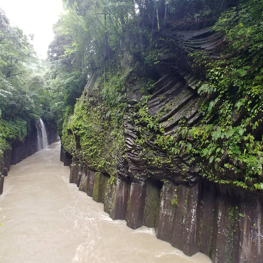 柱状の岩壁の間を流れる、増水した高千穂峡