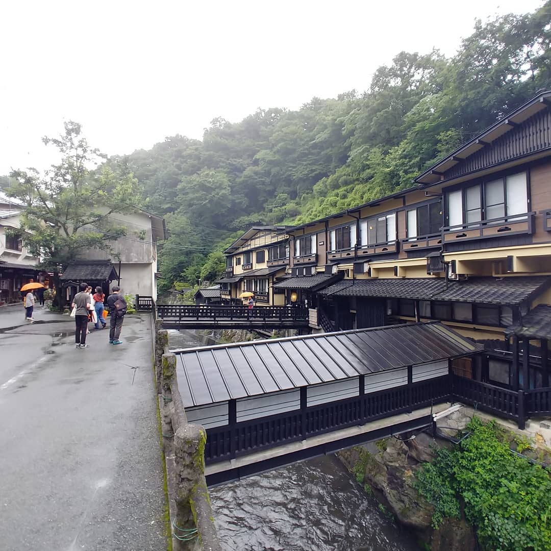 雨の黒川温泉、川沿いに並ぶ木造の旅館