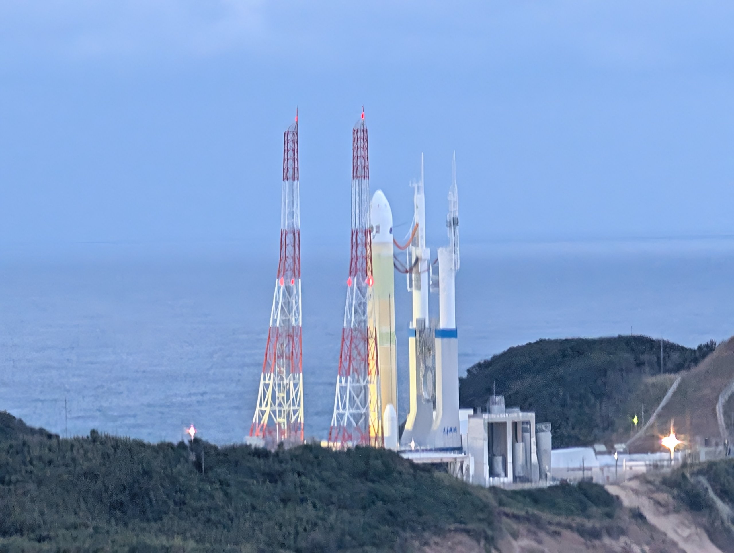 朝の青い空の下、発射台に立つH3ロケット