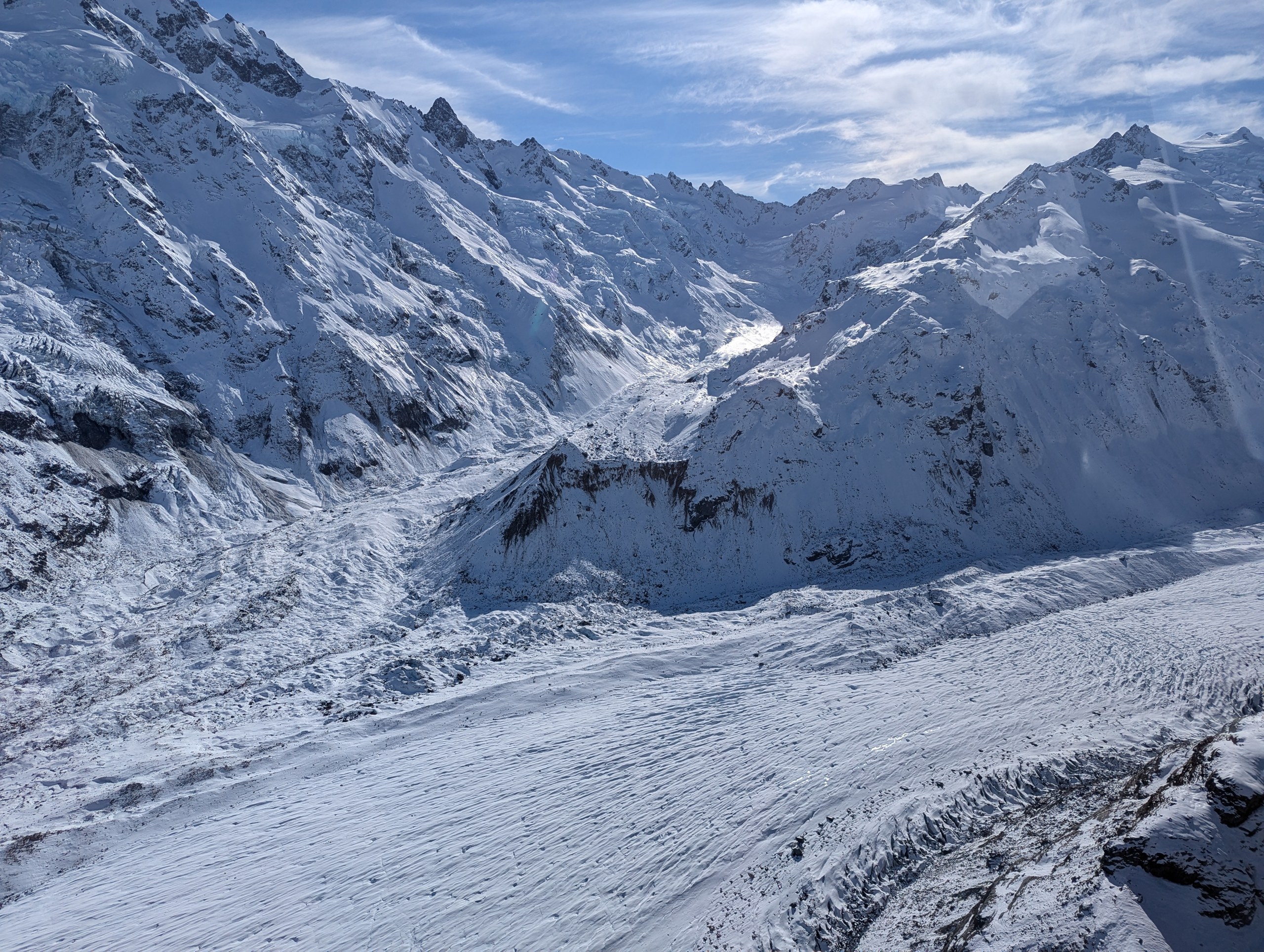 上流に向かうにつれて雪に覆われて白くなる氷河と、両側の雪山
