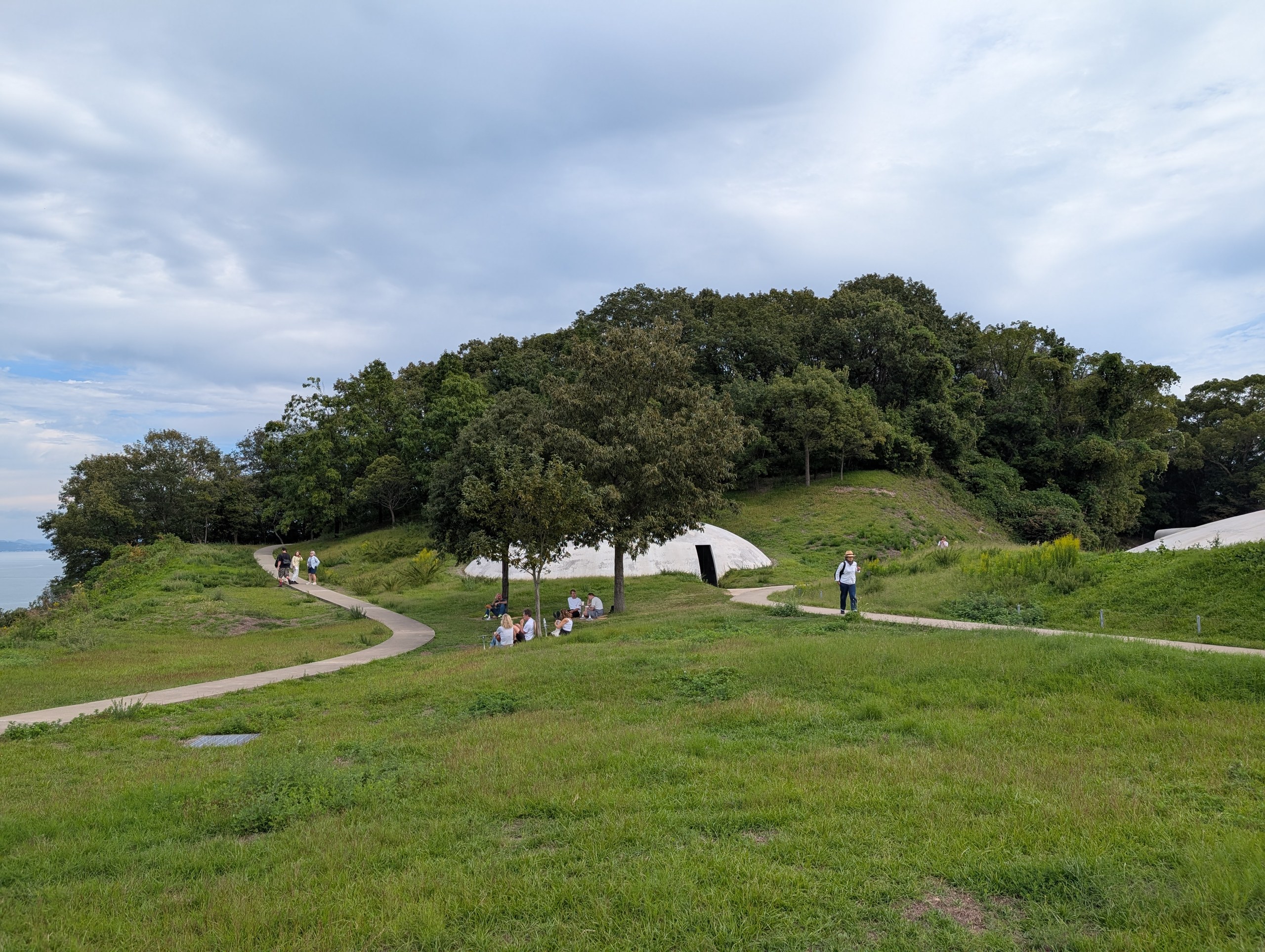 草地の中の小道と、丘のふもとの白く低い建物